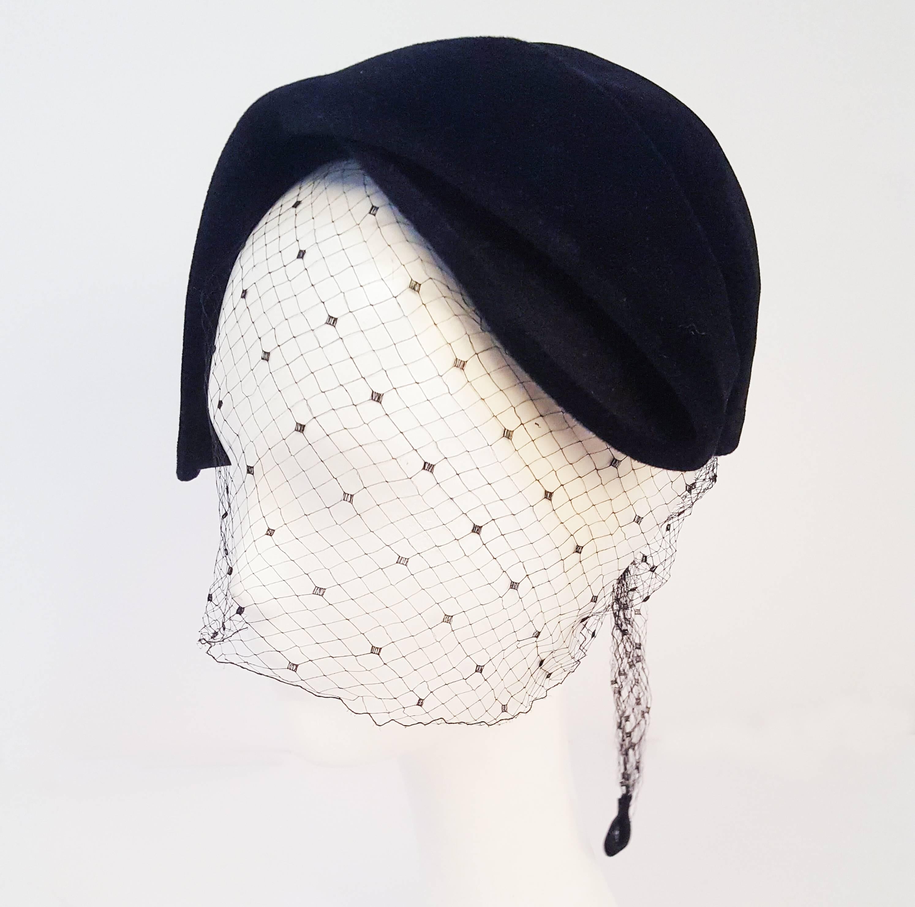 1950s Black Veiled Velvet Hat. Reproduction of a Christian Dior design, sold by Patrice. Features tie-back veil with rhinestone tabs.