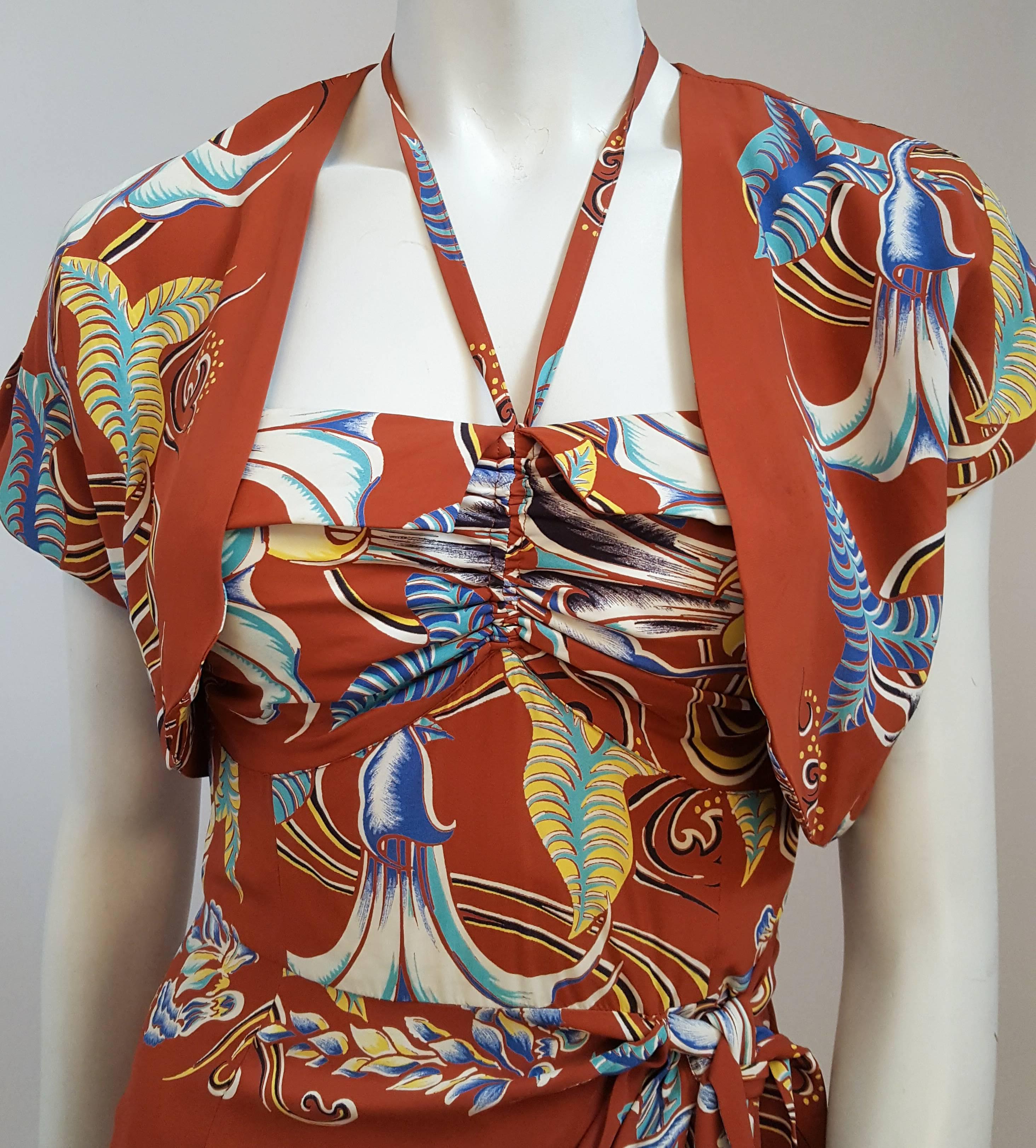 1950s Kamehameha Burnt Orange Tiki Dress & Bolero. Printed rayon. Faux wrap around skirt. Halter neck ties in back. Cotton lined bodice. Metal side zipper. 