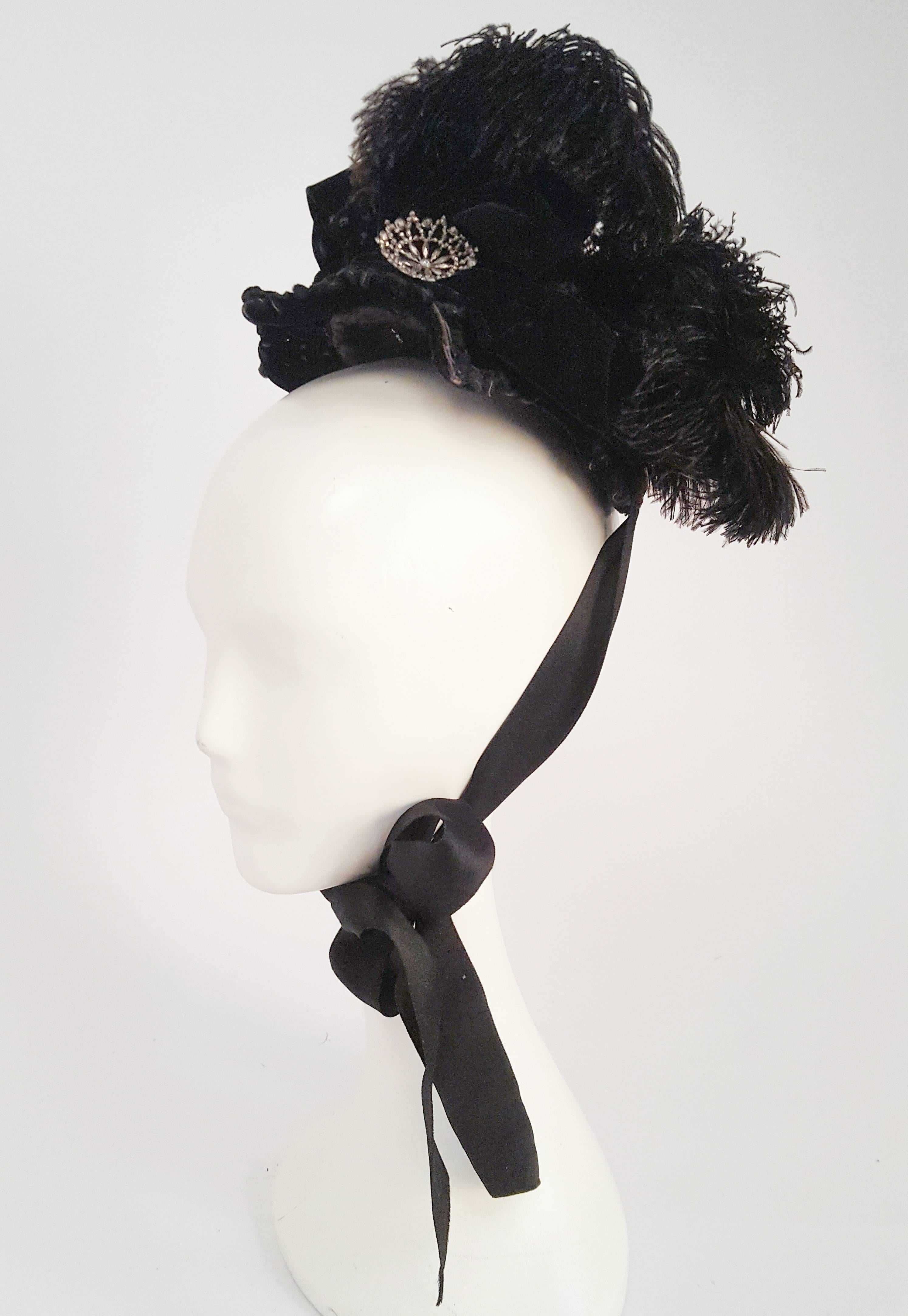 Victorian Black Bonnet w/ Feathers & Beads. Beaded underside of brim. Curled feathers and silk ribbons. Silver toned pin embellishments. Silk ribbon ties.