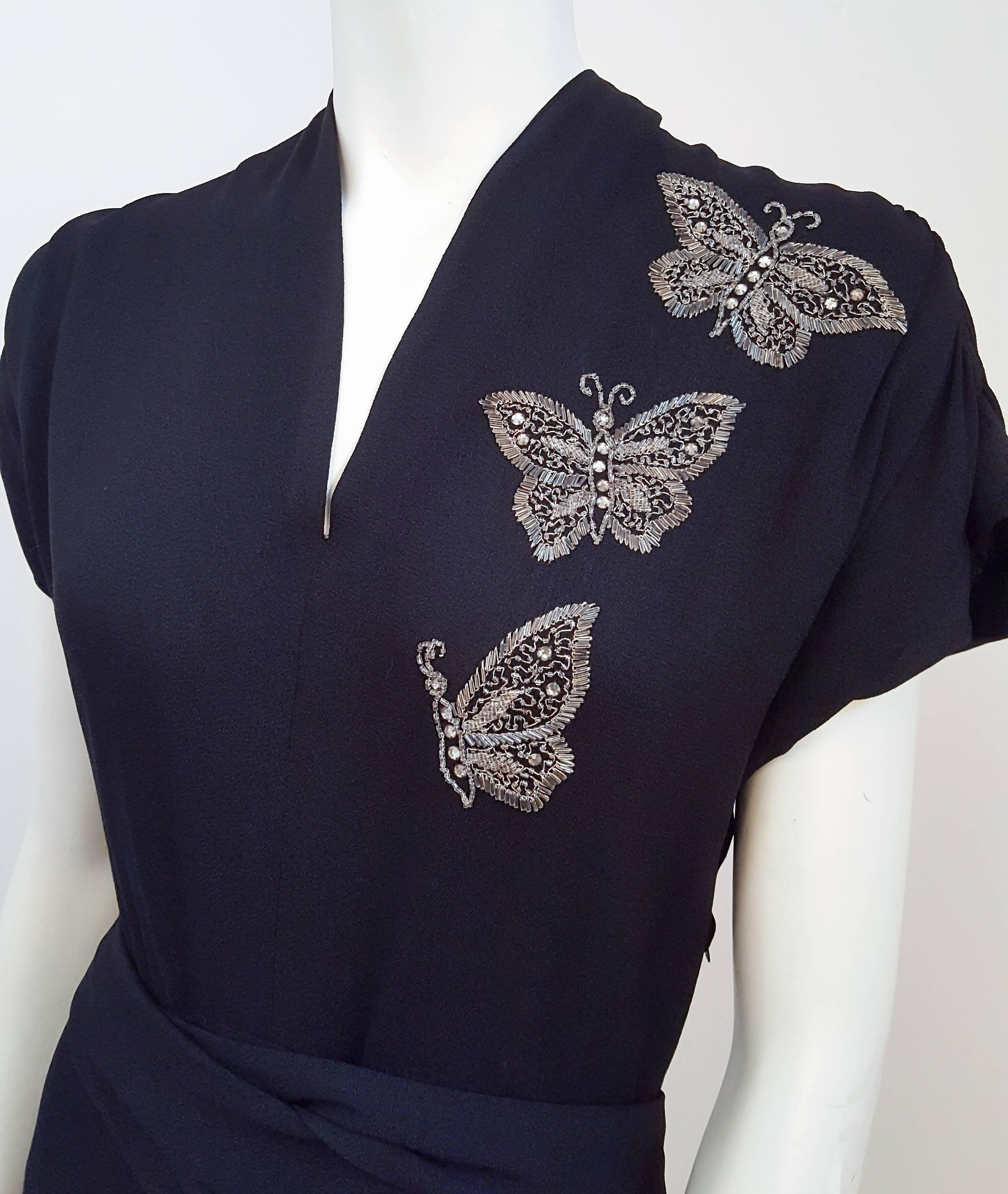 40s Black Crepe Dress w/ Beaded Butterflies. Front crossover detail, buckles in back. Side zip closure.