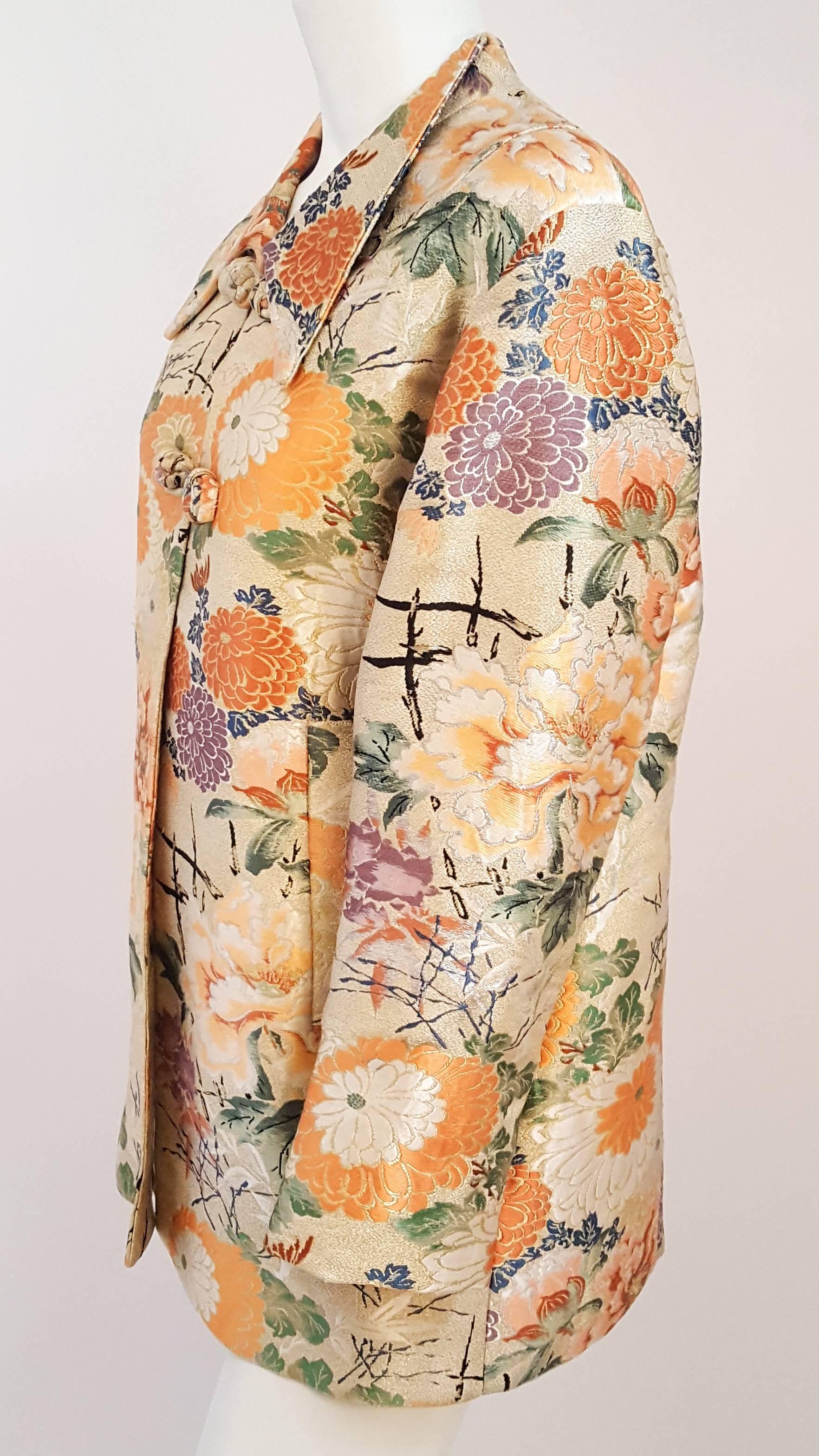 50s Orange Floral Asian Brocade Jacket. Frog clap front closure. Fully lined. 2 front welt pockets. 