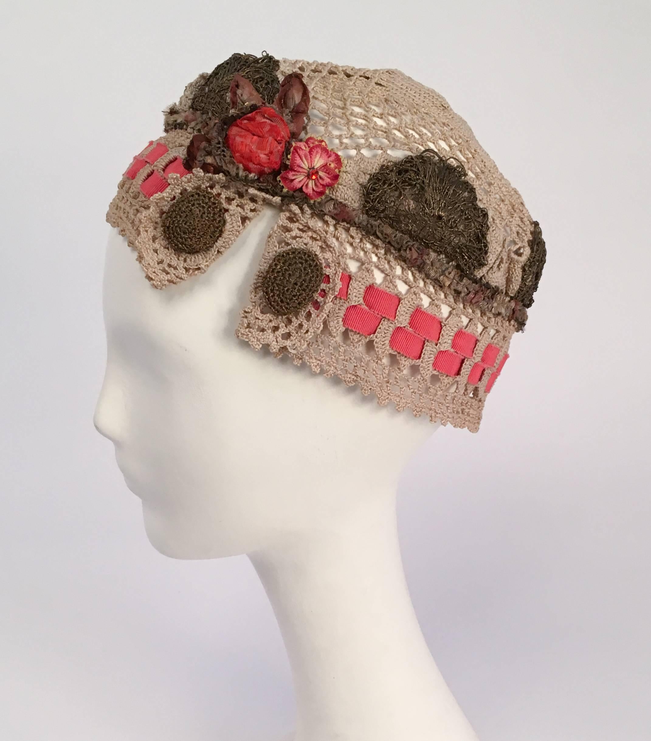 20er Jahre Juliet Cap mit Messing Spitze & Blumen Seite Detail. Durchbrochene Häkelmütze mit Blumenbändern und Messingspitze verziert. 