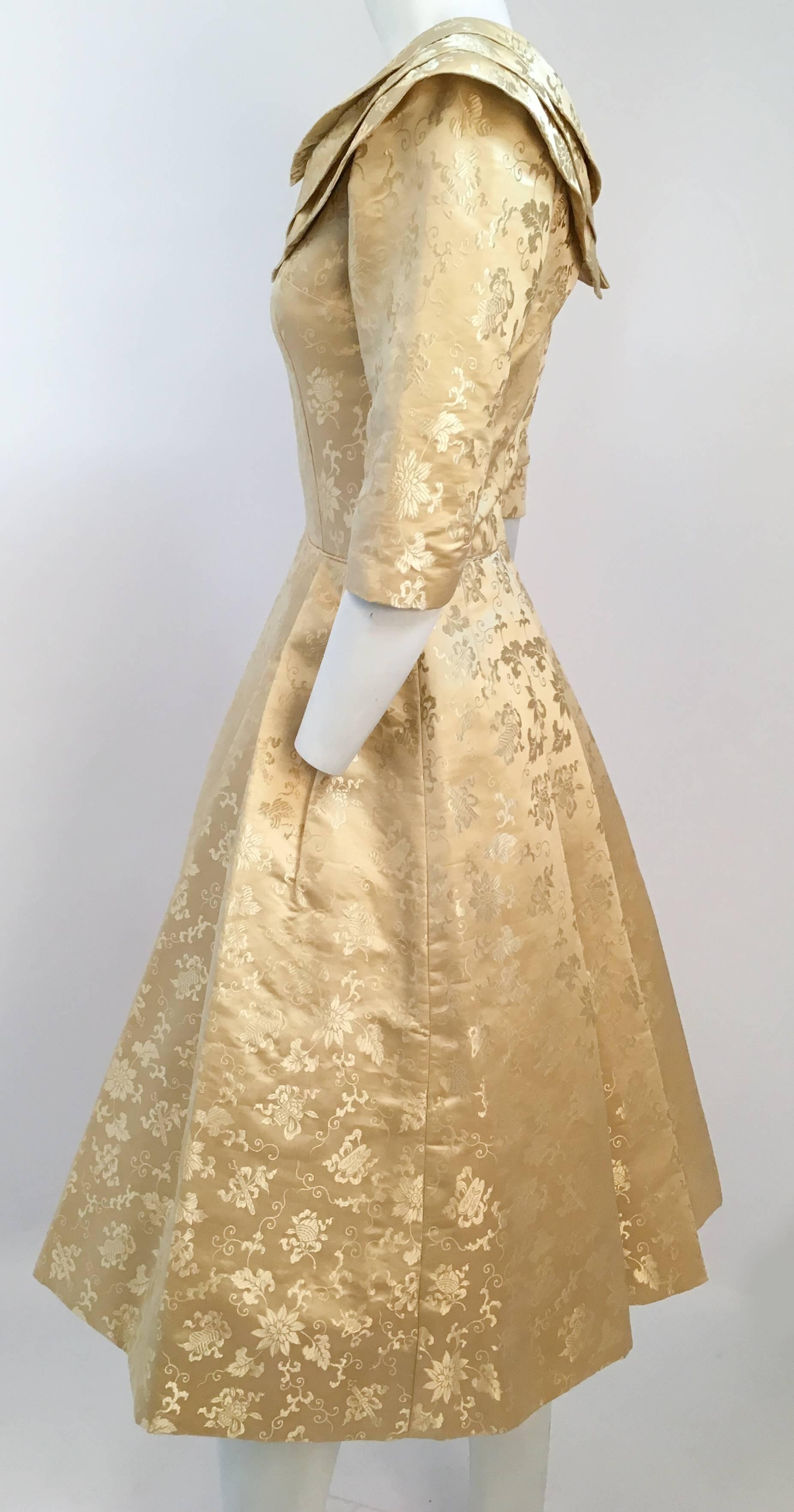 50s Gold Jacquard Cocktail Dress. Pleated skirt is with stiffened lining helps keep structure. Three quarter sleeves. Elegant boat neck collar. Back zips up center with metal zipper and hook and eye closures. 

Size 2, or Small