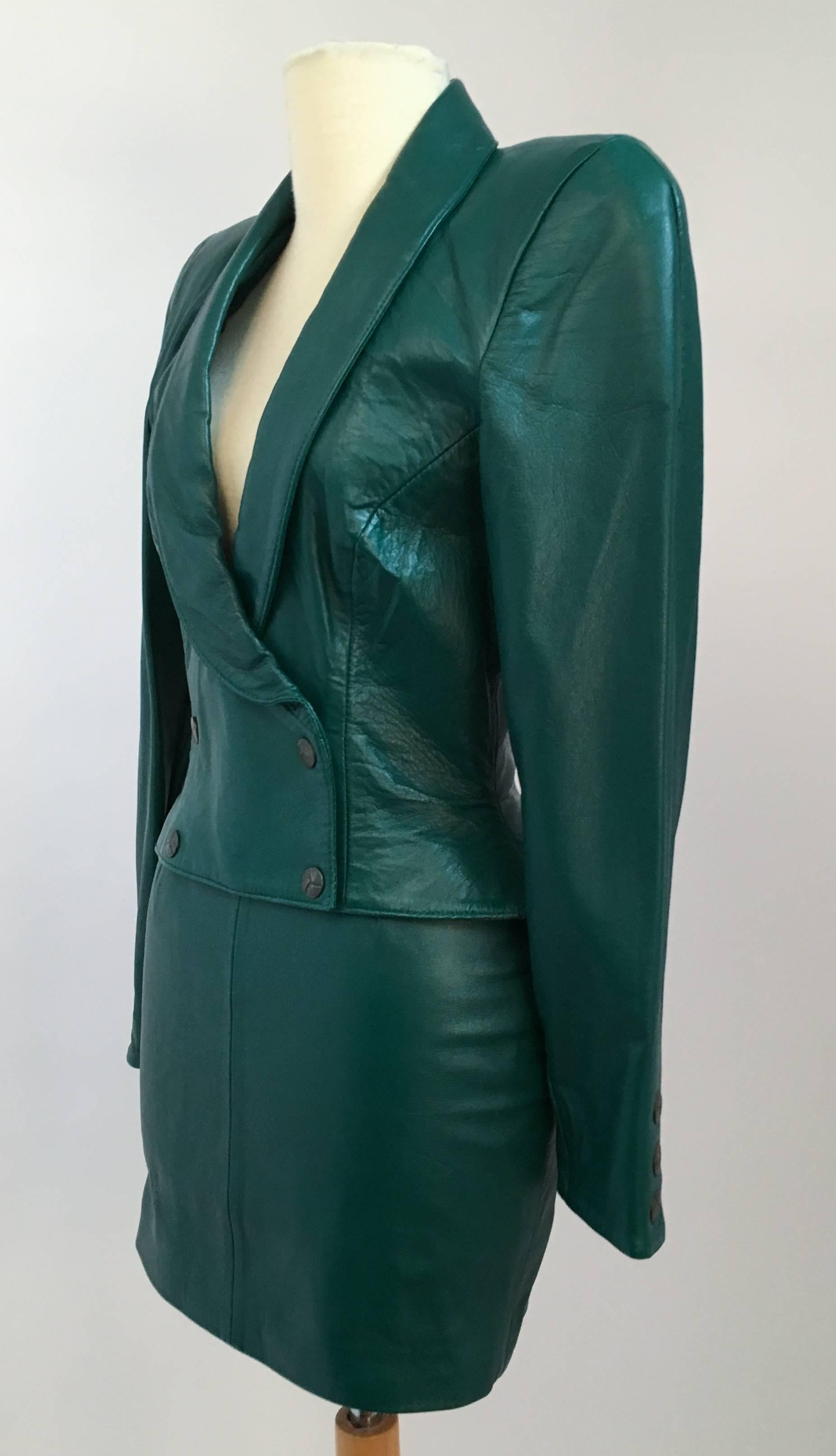80s Michael Hoban North Beach Leather Emerald Green Jacket and Mini Skirt Set. Double breasted jacket with shawl collar and back buckle detail at waist. Miniskirt zips up back.