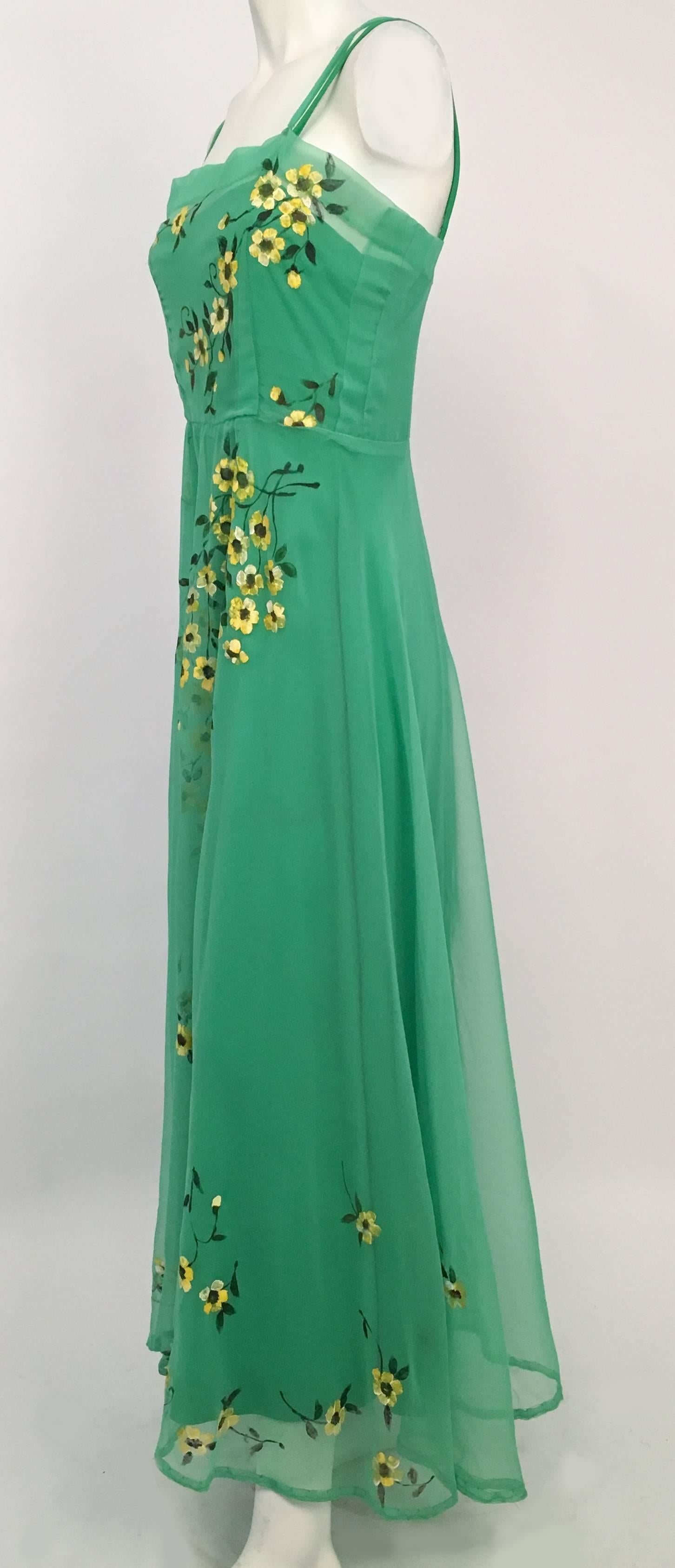 70s Wearable Art Painted Floral Chiffon Maxi Dress. Hand painted yellow flowers decorate green chiffon handmade overdress. Empire waist green jersey underdress. 