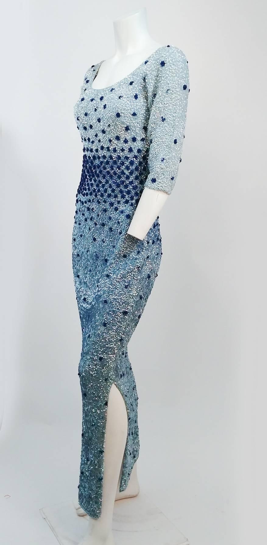 60s Blue Sequin Cocktail Dress. Hand embellished all over sequins in iridescent light blue, with three dimensional roses in dark blue on a sweater knit dress. Zips up back. On side slip on side for ease of walking. 