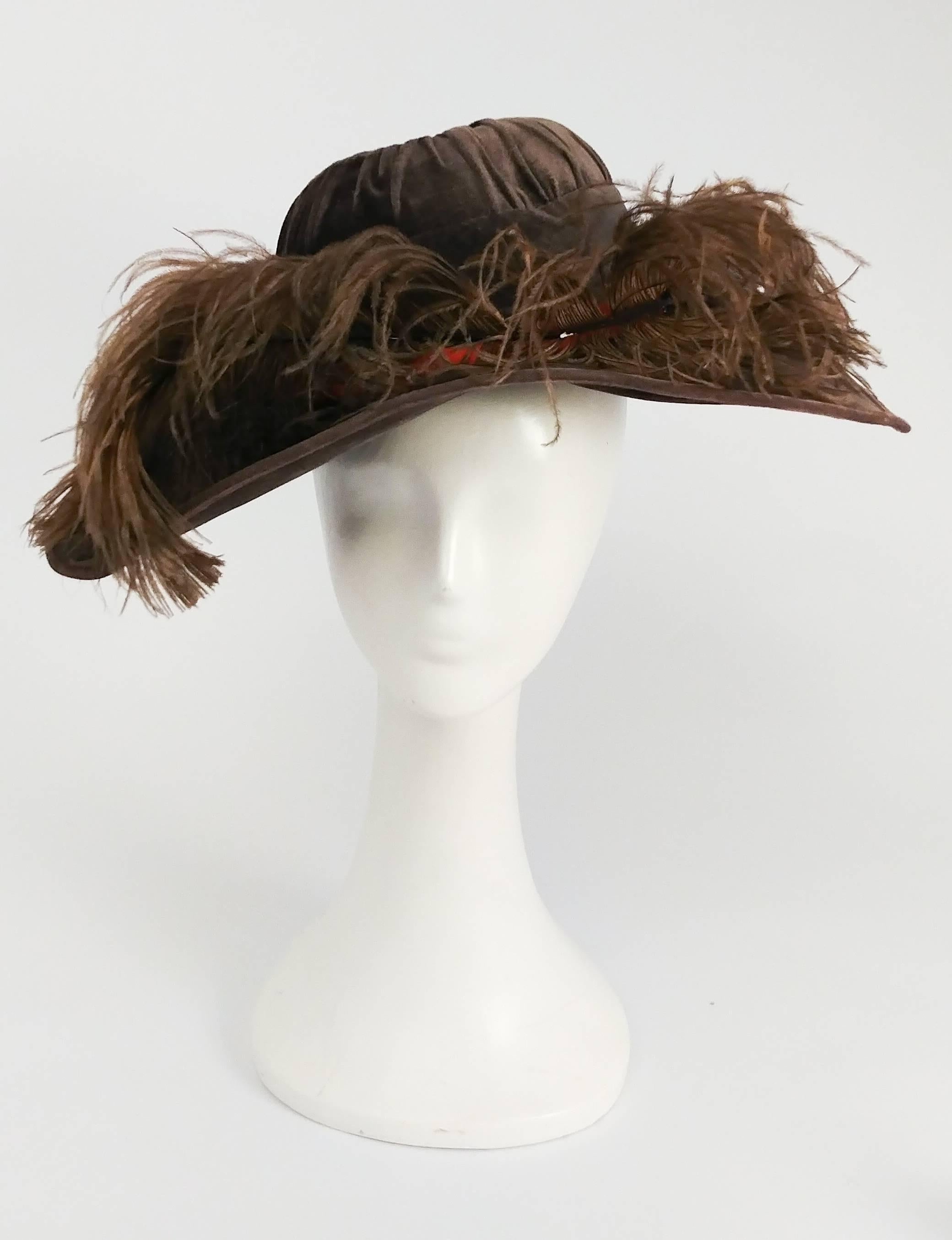 Edwardian Taupe Picture Hat w/ Feather Trim. Wide brimmed fur velvet hat, all-over feather trim on a contrast orange hat band. Crown of hat is gathered. Lined in silk, slight press on underside of hat shown in photo. 