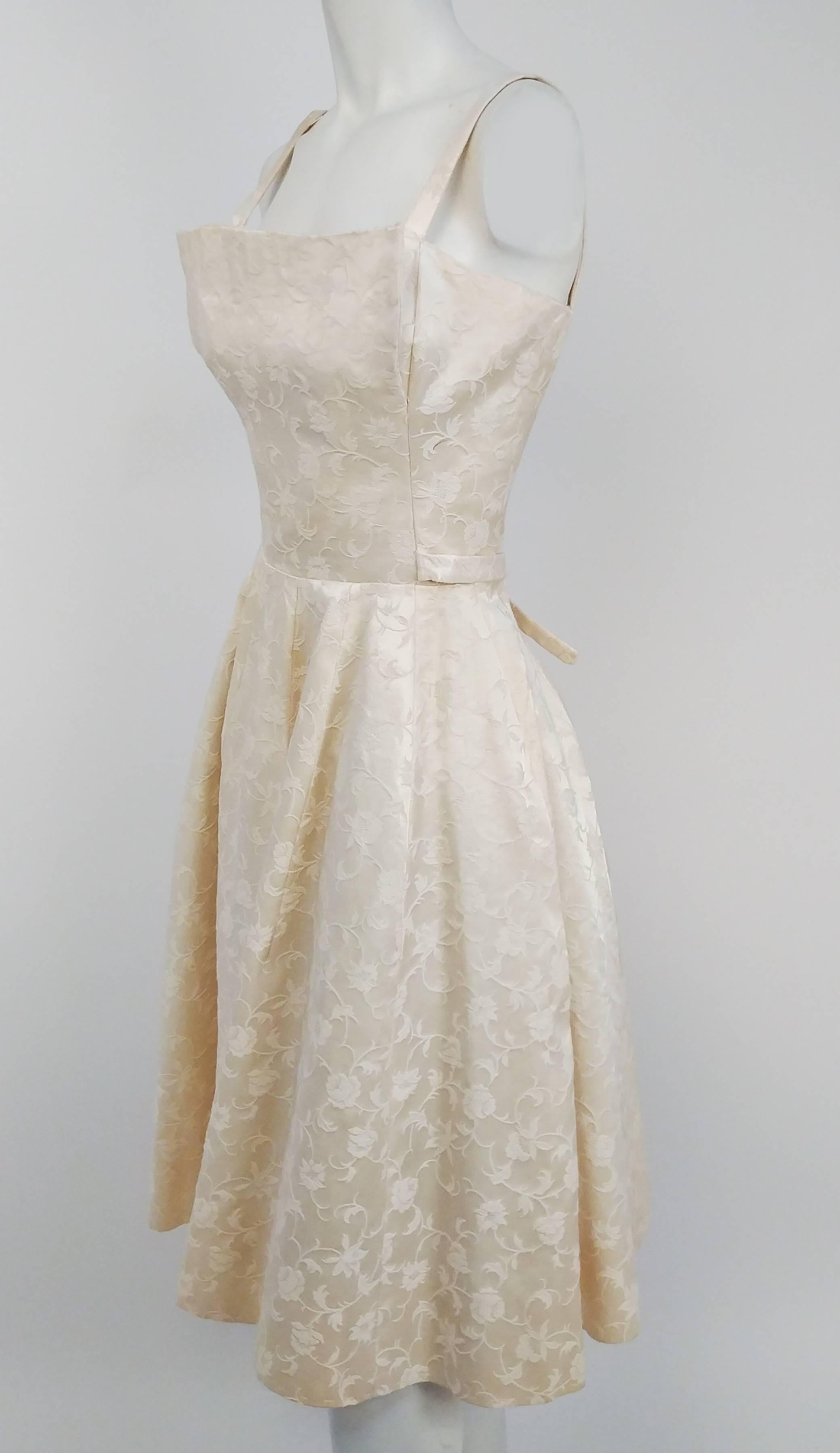 1950s White Jacquard Cocktail Dress. Interesting origami bodice design. Ties at waist at back. Built in tulle petticoat. 