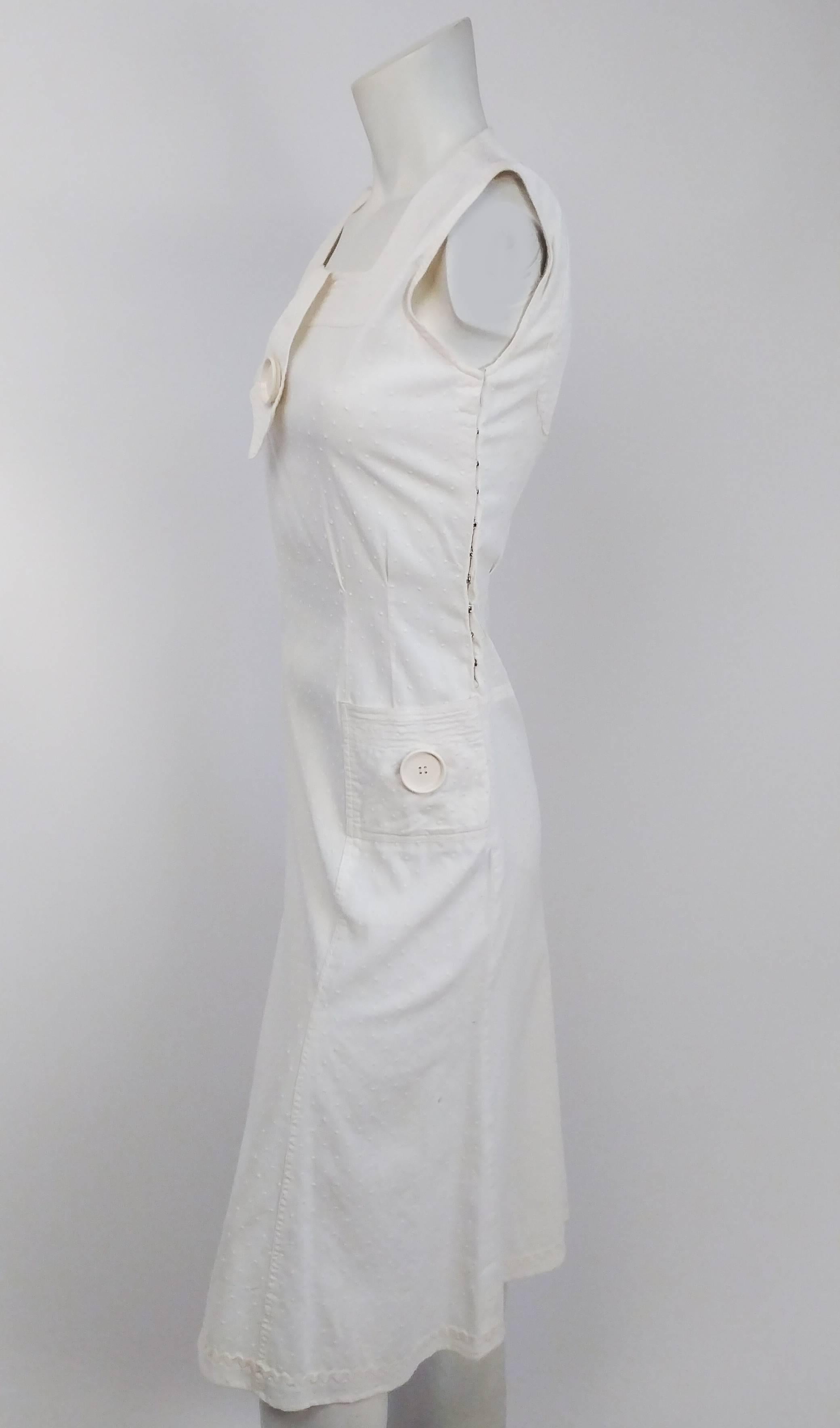 1920s White Swiss Dot Day Dress w/ Large Button Detail. Side snap closure. Faux neck tie detail w/ large button. Two square pockets with matching button details. Back cut-out detail. Rick rack trim on hem.  