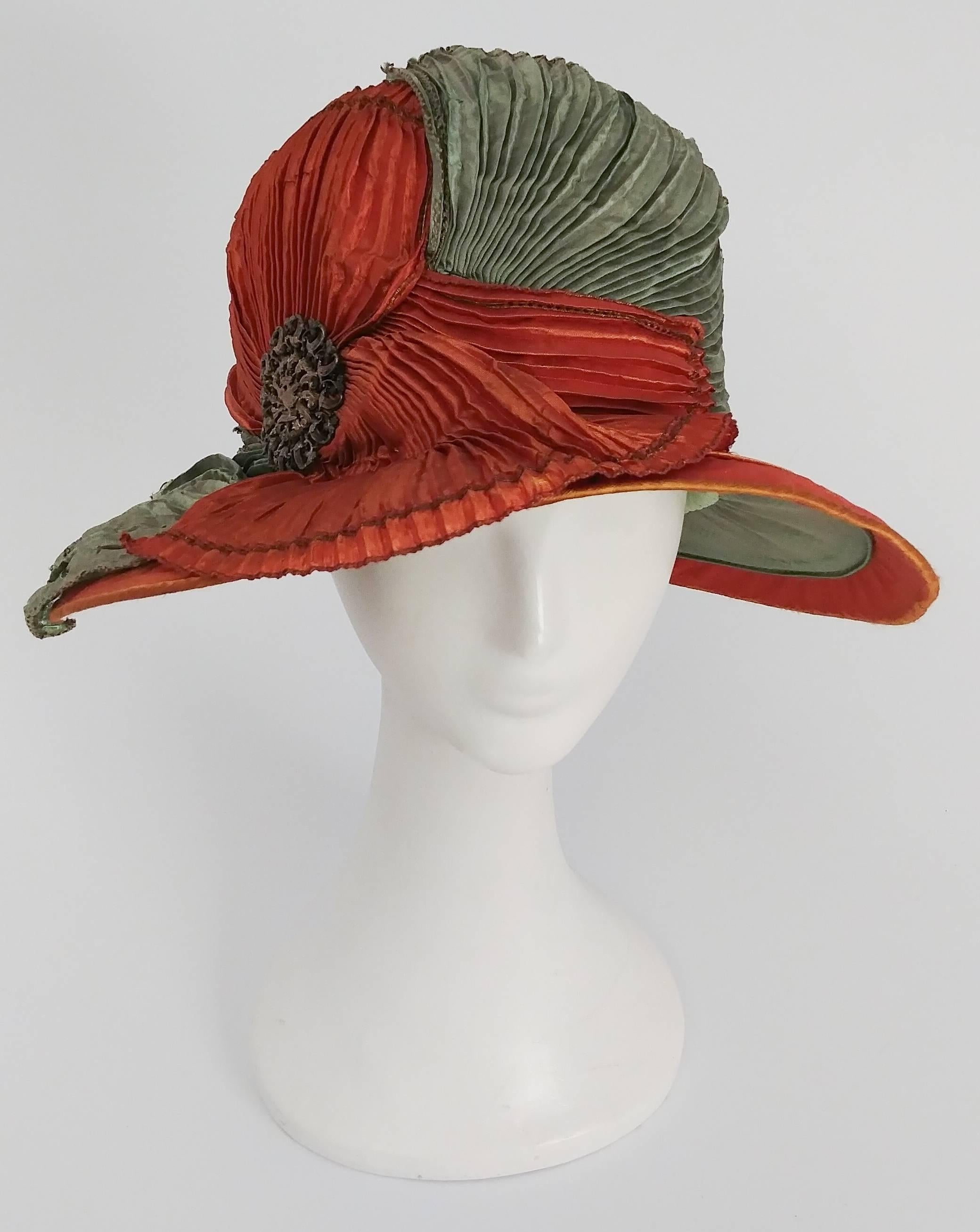 1920s Burnt Orange & Seafoam Green Wide Brim Cloche Hat. Pleated fabric drapes across the front of this hat, furthered embellished with art nouveau pin on side. Sits low over eyes for true 20s look. 