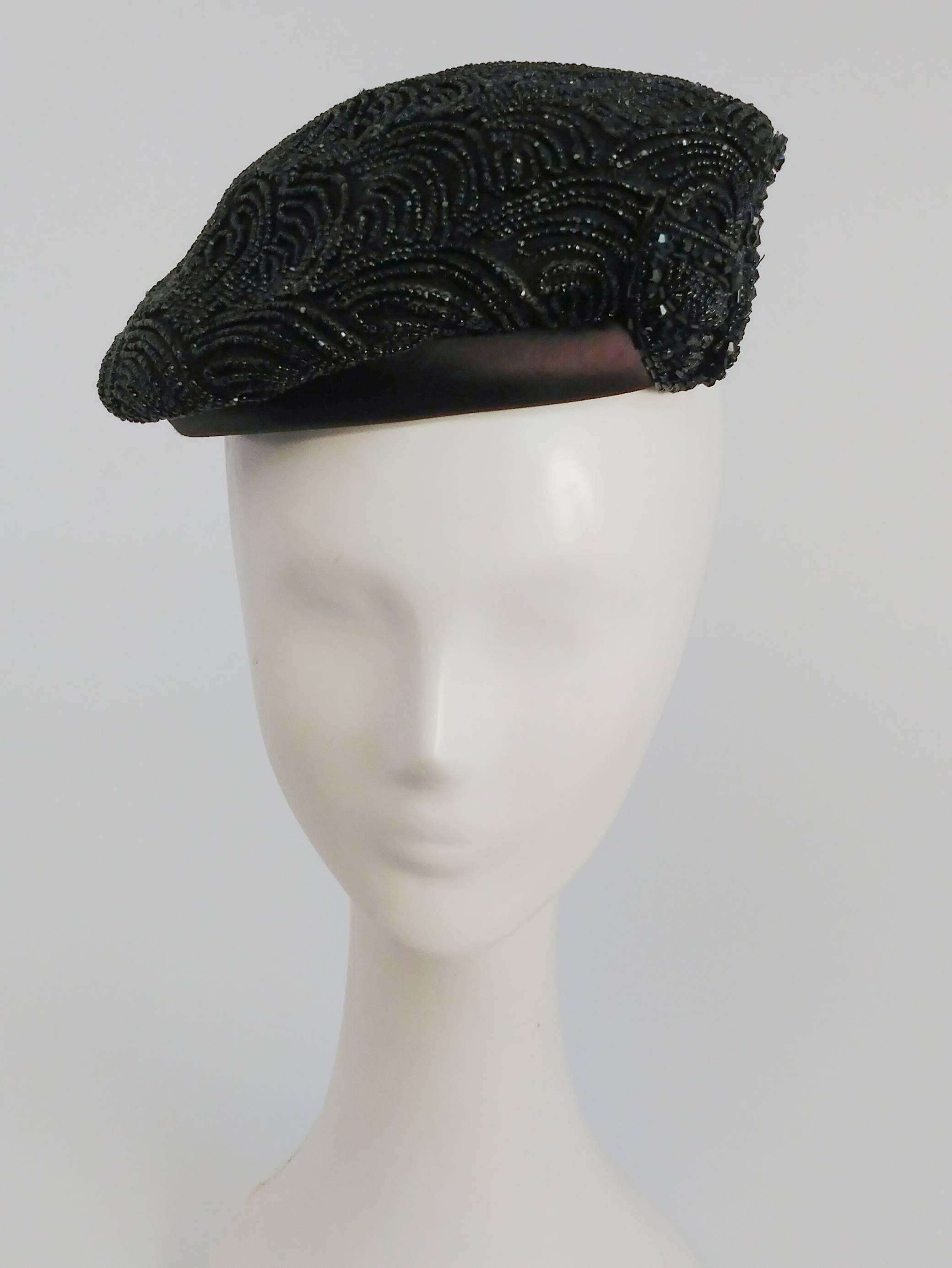 1940s Black Beaded Beret. All-over beaded hat perches on top of the head. One side is further embellished with a beaded applique leaf detail. Brown satin trim. 