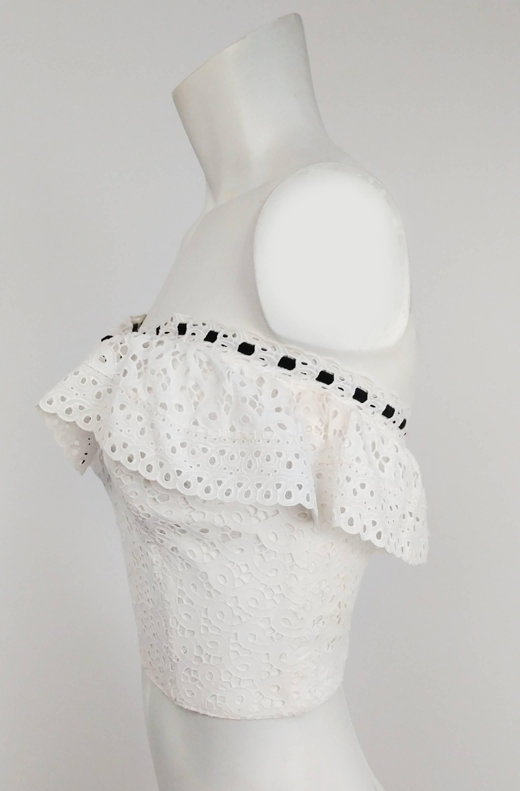 1950s White Cotton Eyelet Lace Bustier Top. Black ribbon trim ties in bow in front over ruffle. Fully lined and boned. Hook & eye back closure.