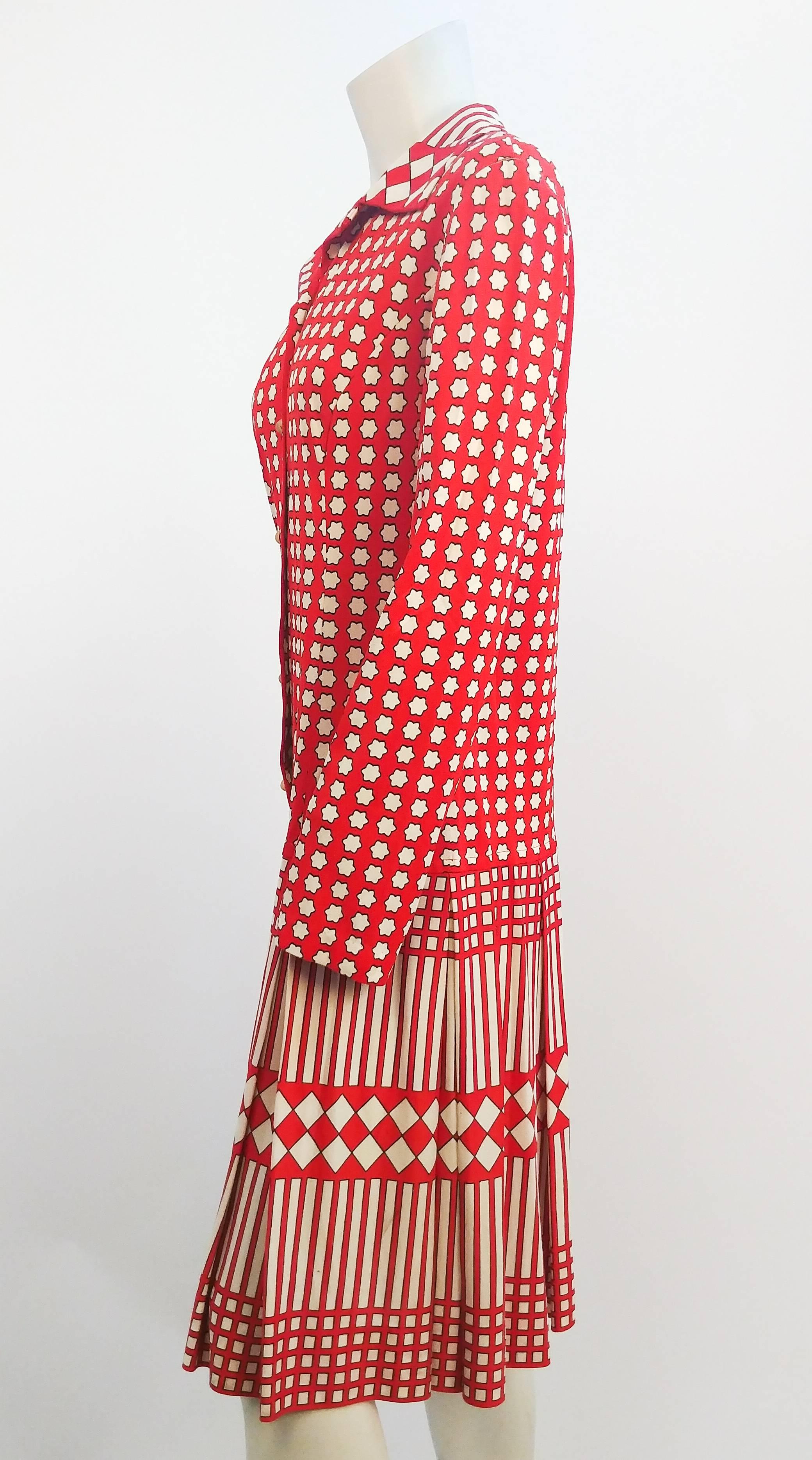 1960s Red & White Print Drop Waist Dress. Geometric print design consists of flowers, diamonds, and stripes. Pleated skirt. Buttons up front with gold hammered buttons. Polyester stretch jersey. 