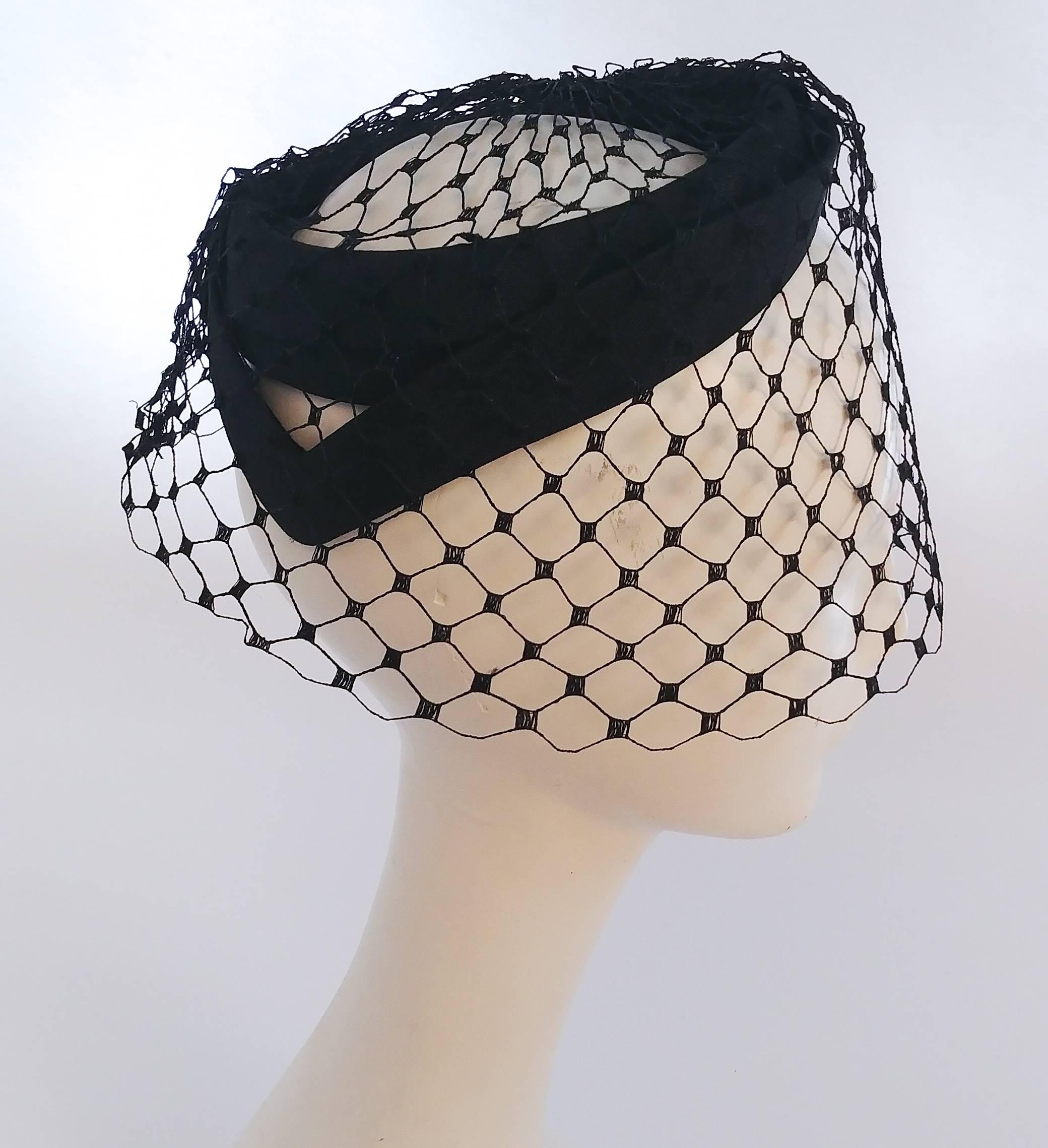 1960s Black Veil Cocktail Hat. Sits slightly back on head, hat is stiff enough to lightly clamp in place while remaining comfortable. Simple and elegant. One size fits most.