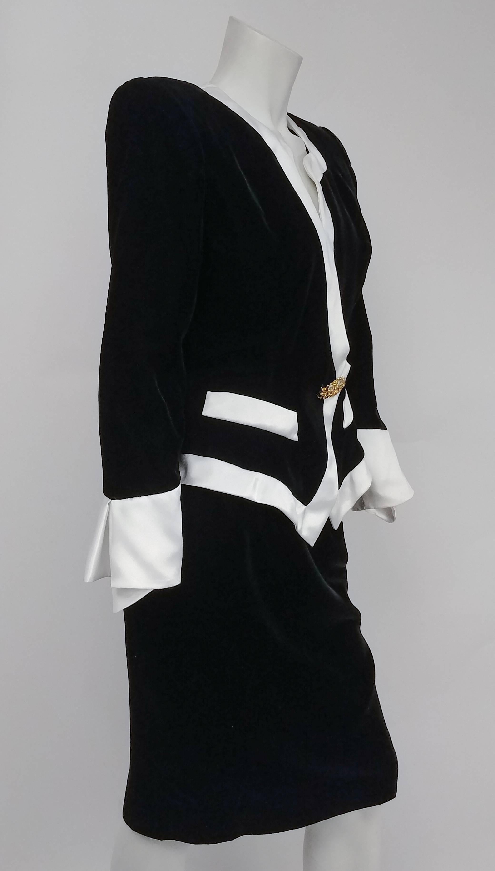 1980s Lilli Rubin Black Velvet Jacket & Skirt Suit Set w/ White Satin Trim. Asymmetrical jacket collar detail, this jacket snaps close at front, with decorative rhinestone brooch.  Dramatic side contrast cuffs on the sleeve. Skirt zips up side. 