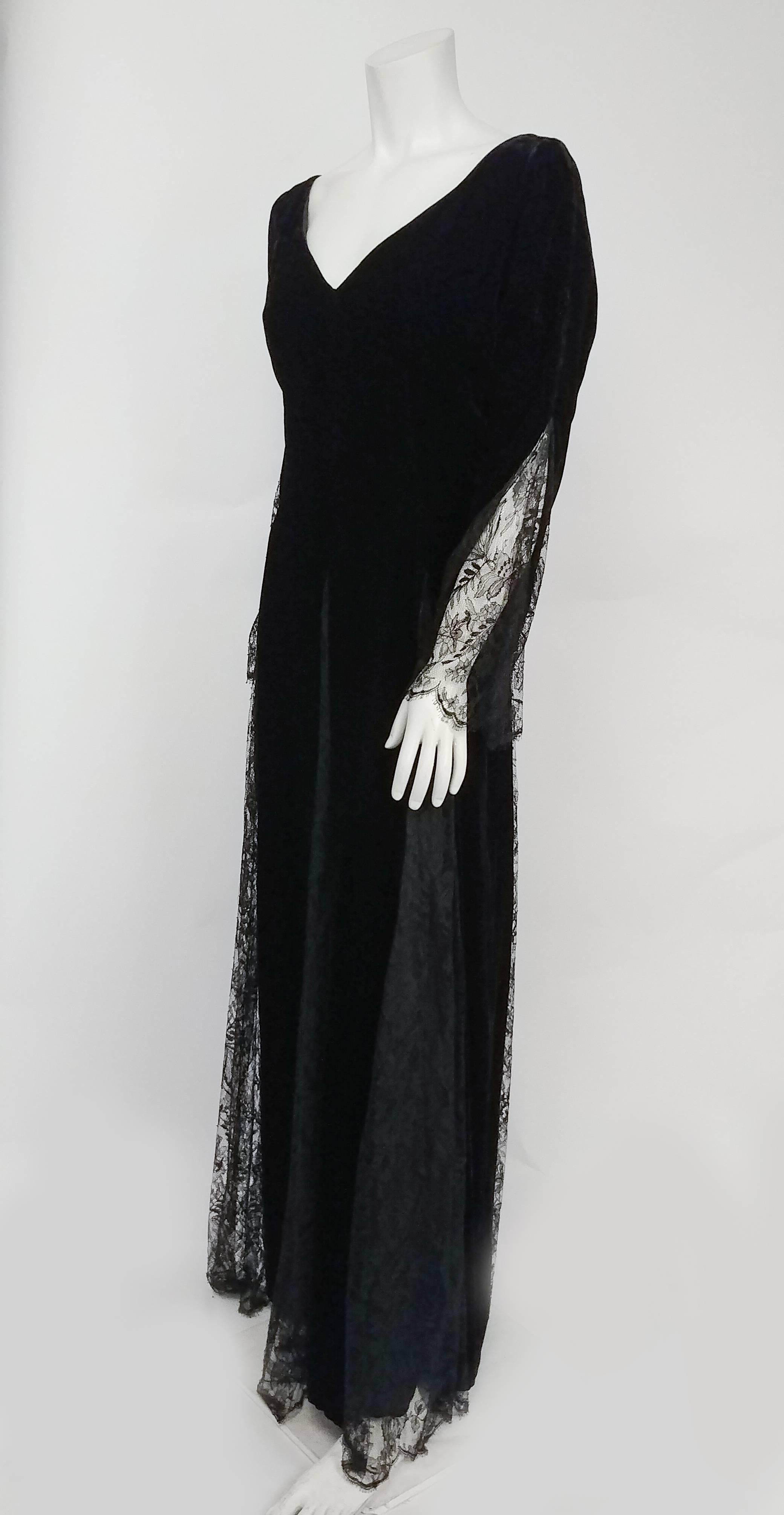 1980s Bill Blass Black Velvet Gown w/ Lace Detail. Channel your inner Morticia Addams with this floor-sweeping elegant velvet gown with dramatic lace sleeves. Flattering wide V neck. Zips up back. 

The measurements for this gown are as