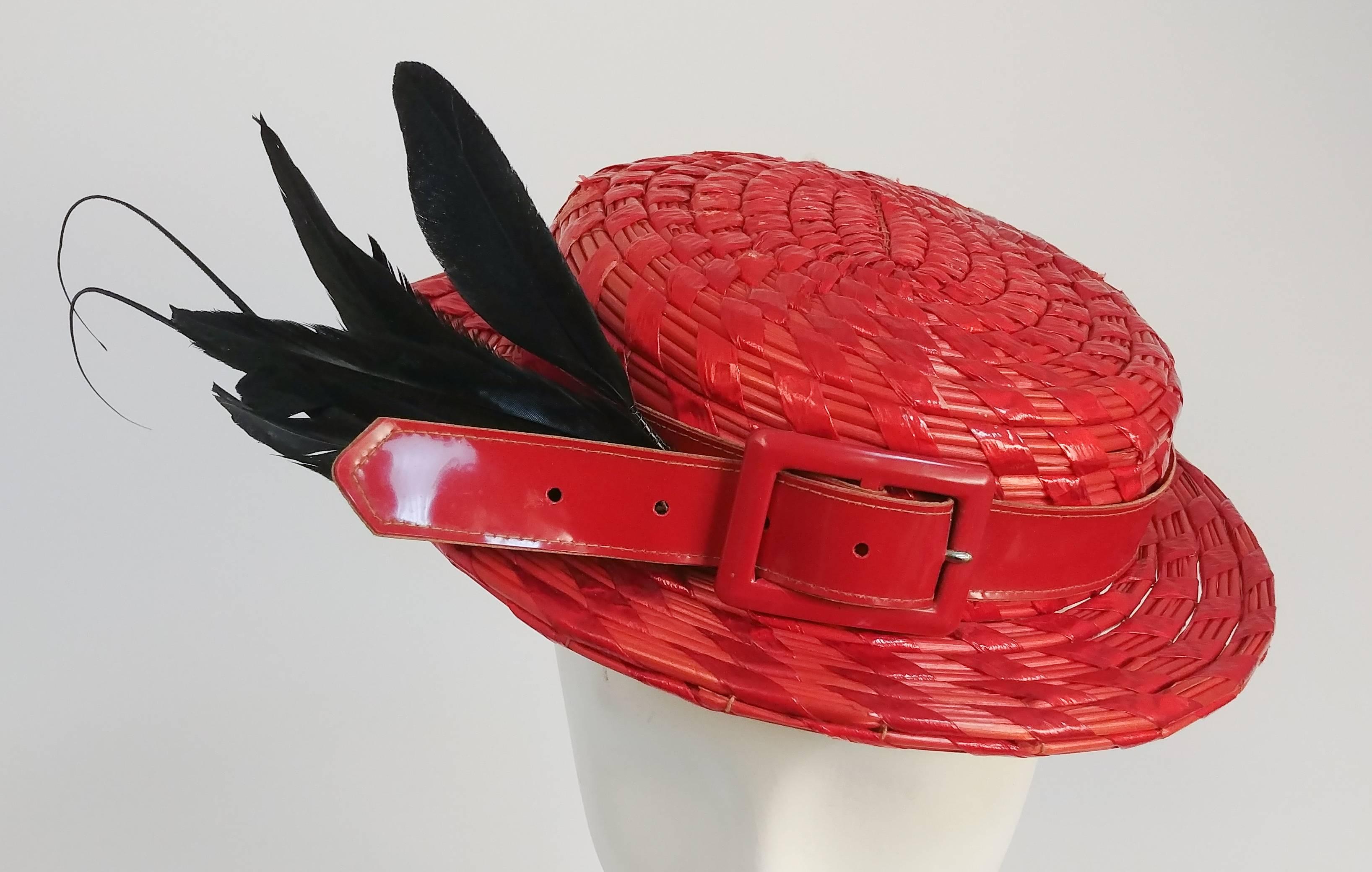 1950s Red Hat with Patent Leather Hatband & Feathers. Red woven hat featuring red patent leather belt as hatband and black feathers cocked towards one side. Held to back of head with elastic.