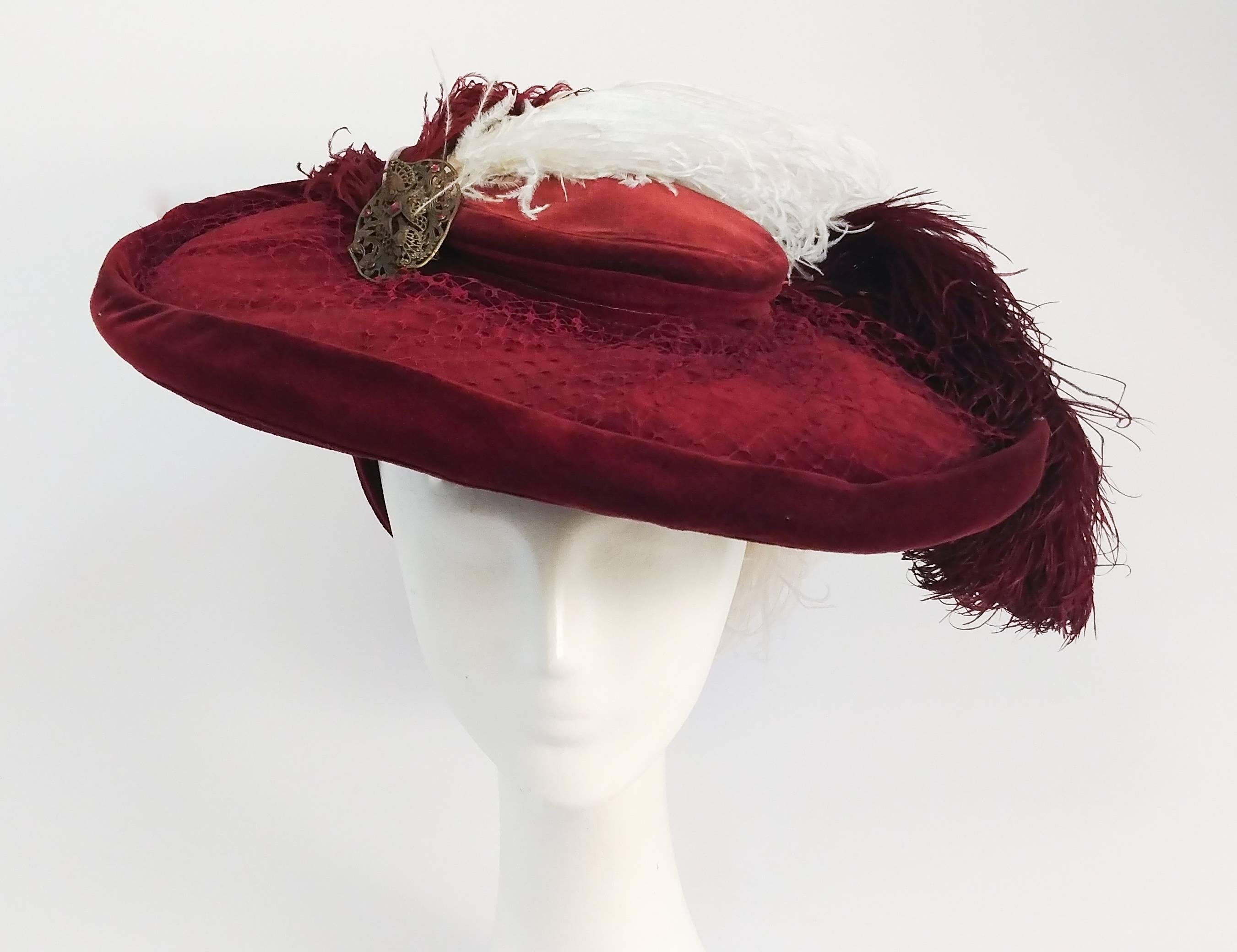 1940s Red Bordeaux Velvet Hat w/ Ostrich Feathers. 1940s version of an Edwardian picture hat. Trimmed with netting all over the brim of the hat and finished with an art nouveau style pin. Held to head at back.