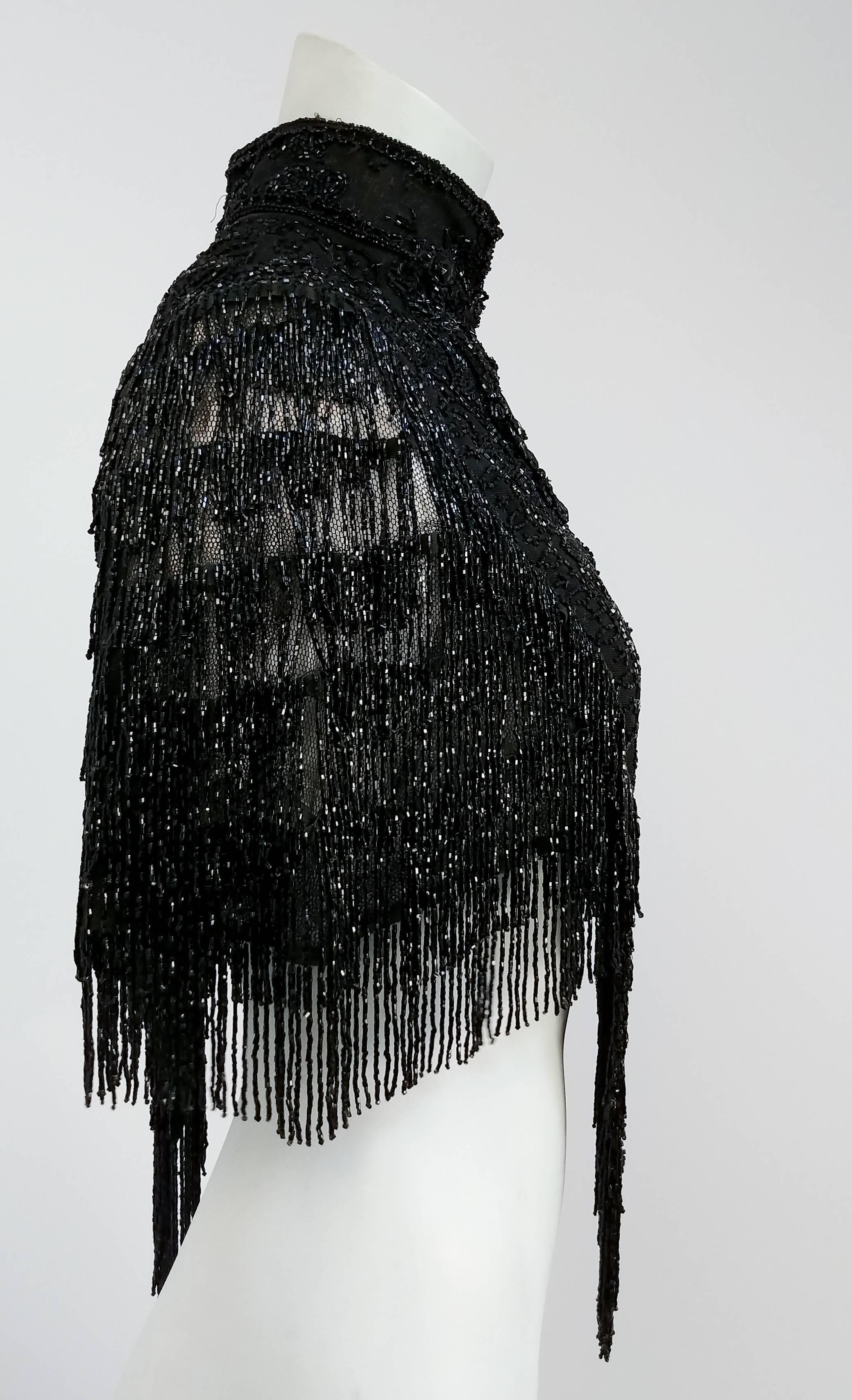 Victorian Jet Bead Capelet w/ Fringe. Clasps in front w/ hook and eyes. Small shoulders. Wool lining on neck, beaded on mesh. 