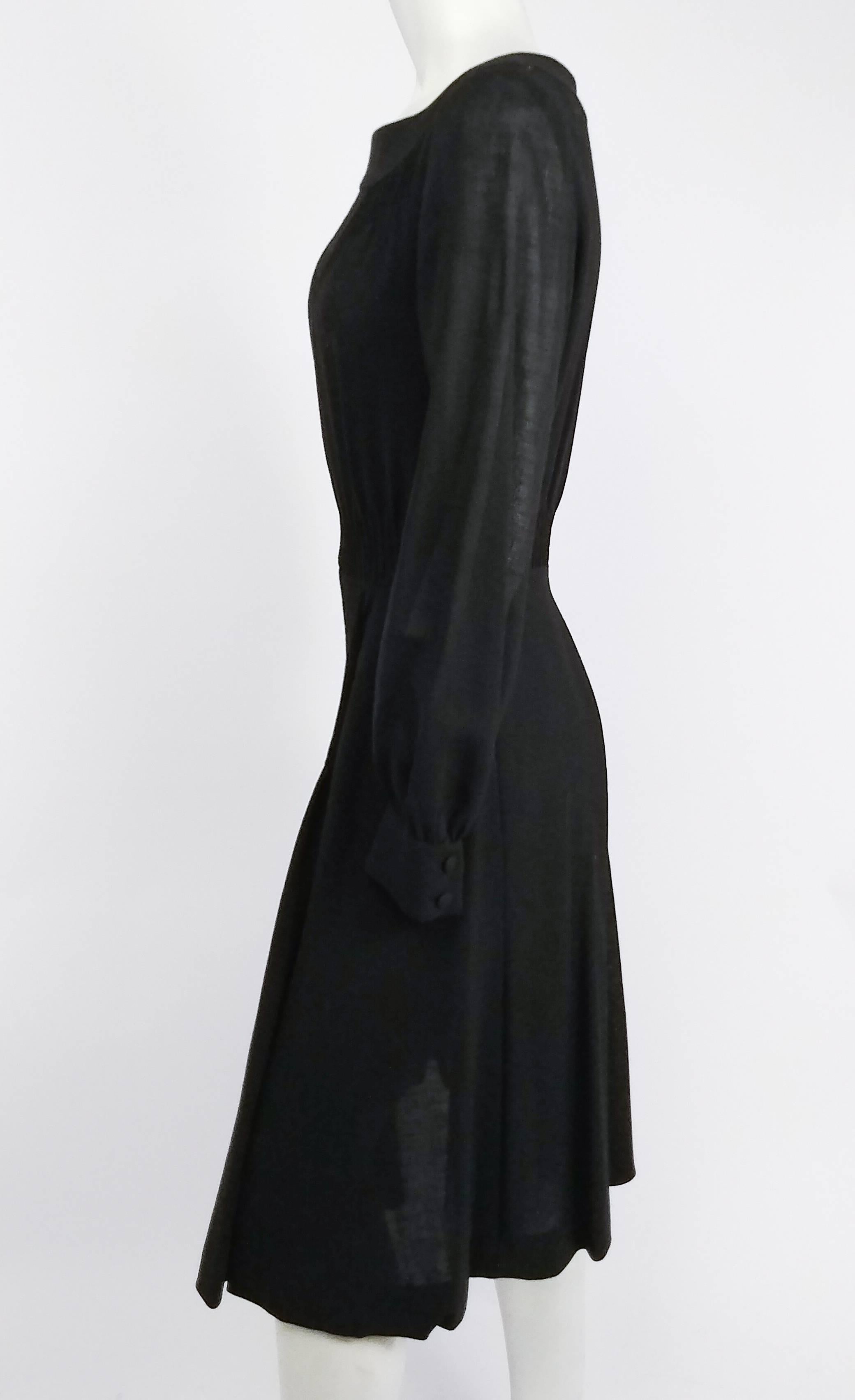 Vestido de día negro con fruncidos Valentino de los años 60. 100% lana. Cierre de cremallera metálica en la parte trasera. Cuerpo fruncido en la cintura, con detalle de smocking en la falda delantera. 