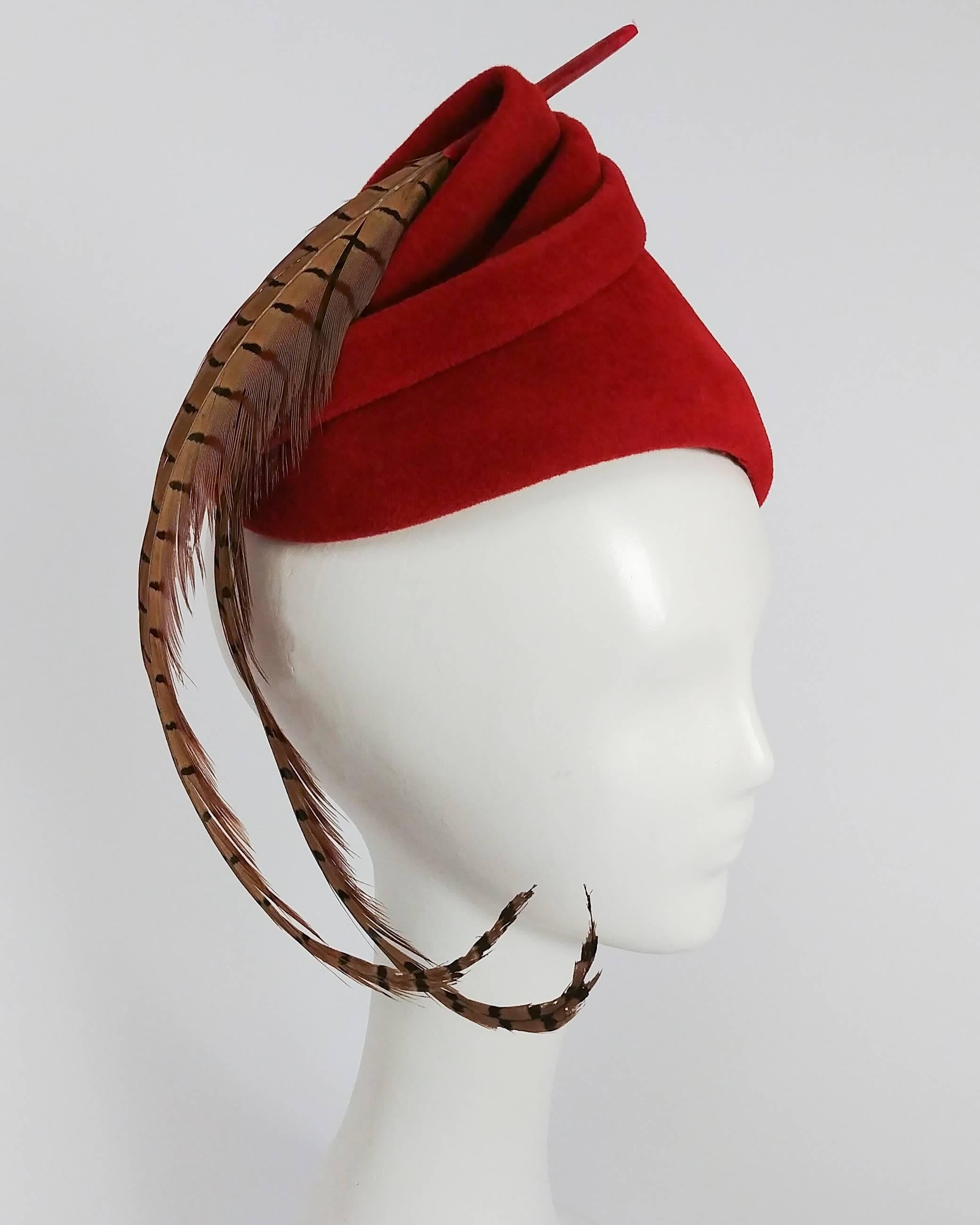 1940s Red Felt Surrealist Hat w/ Pheasant Feather. Two curled pheasant feathers adorn top of the hat and fall below the chin. Ruched top of hat further embellished with felt loop to create whimsical spiral effect.  
