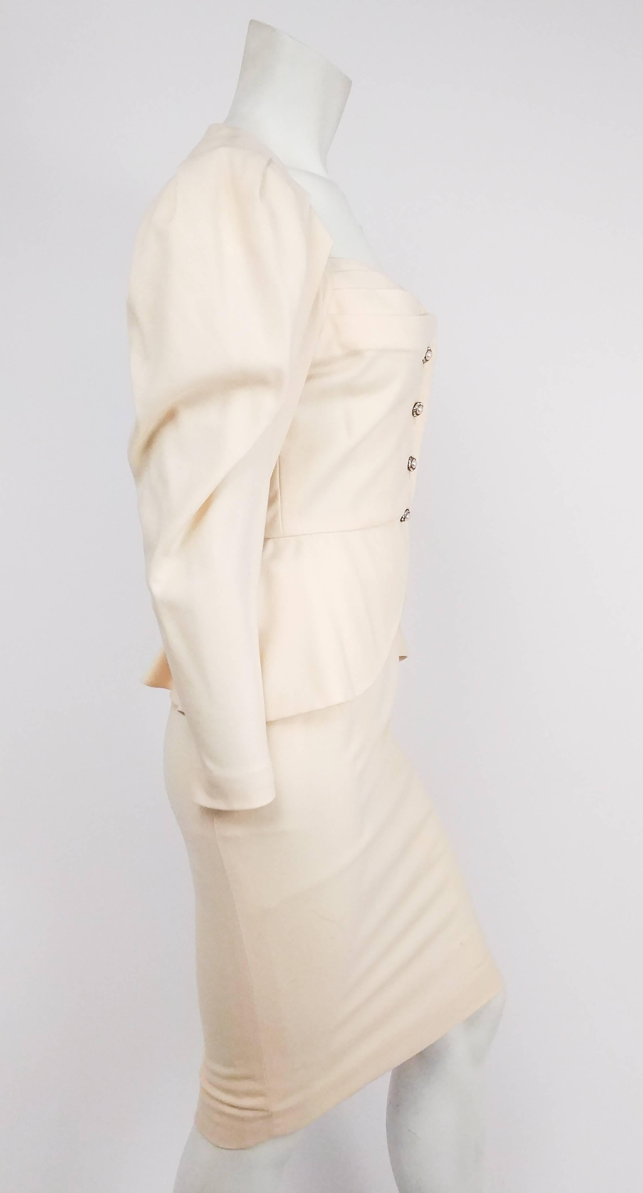 1980s Vicky Tiel Cream Suit Set. Pleated sweetheart neckline with pearl and rhinestone buttons. Pleated puffed sleeves. Peplum flares out slightly in back. Pencil skirt zips up side. 