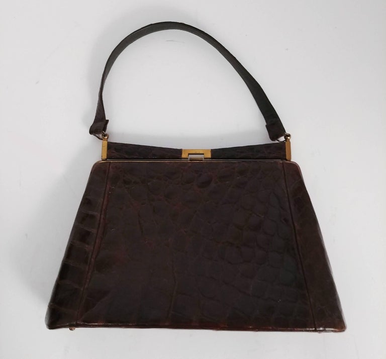 1950s Brown Alligator Handbag. Tapered trapezoid shape. Gold tone hardware. Comes with mirror. 