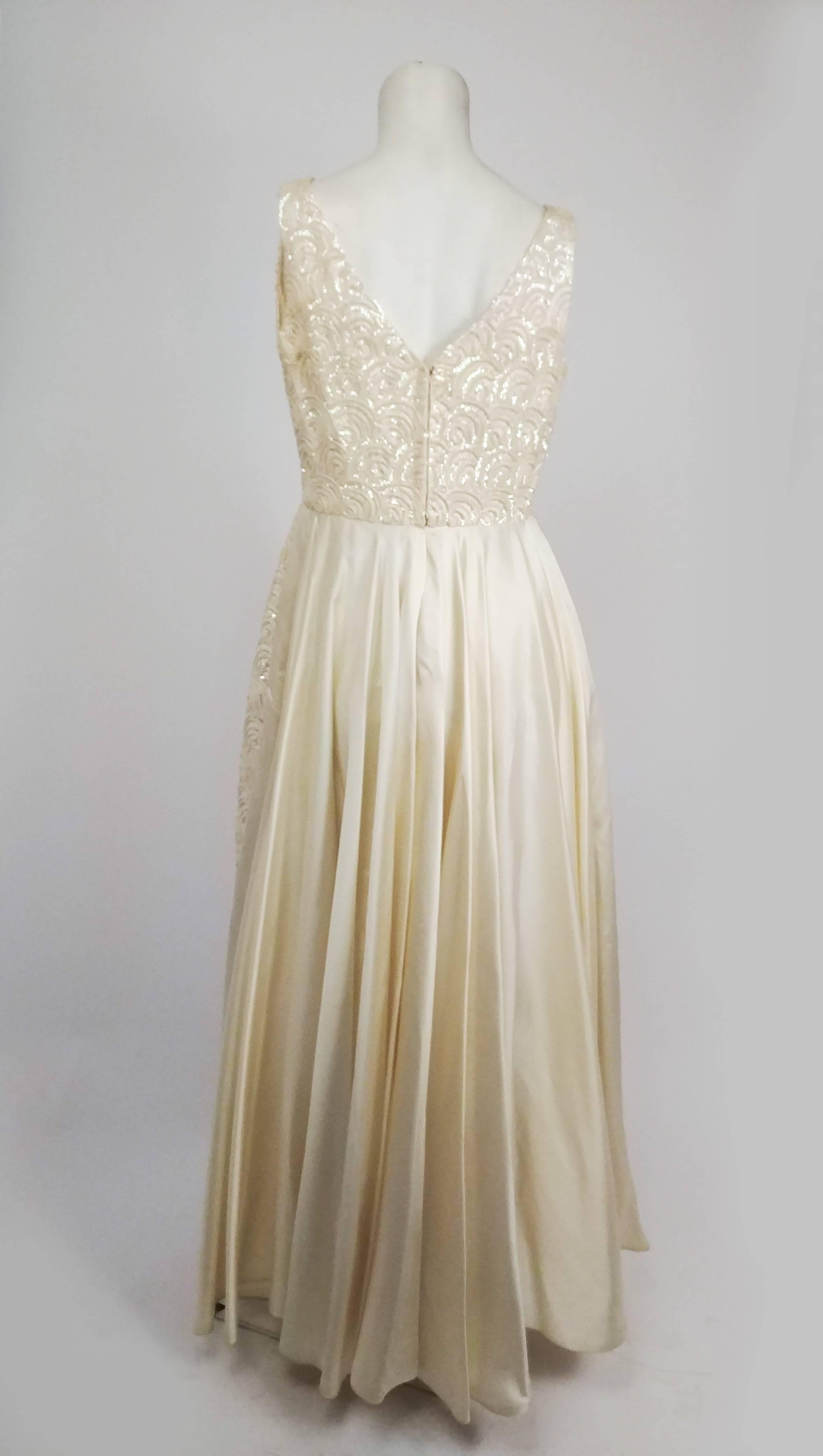 1960s White Sequin Long Gown. Iridescent sequins in a wave pattern sewn over the entirety of this dress. Fitted at waist, flared skirt. V neckline. Zips up back. 