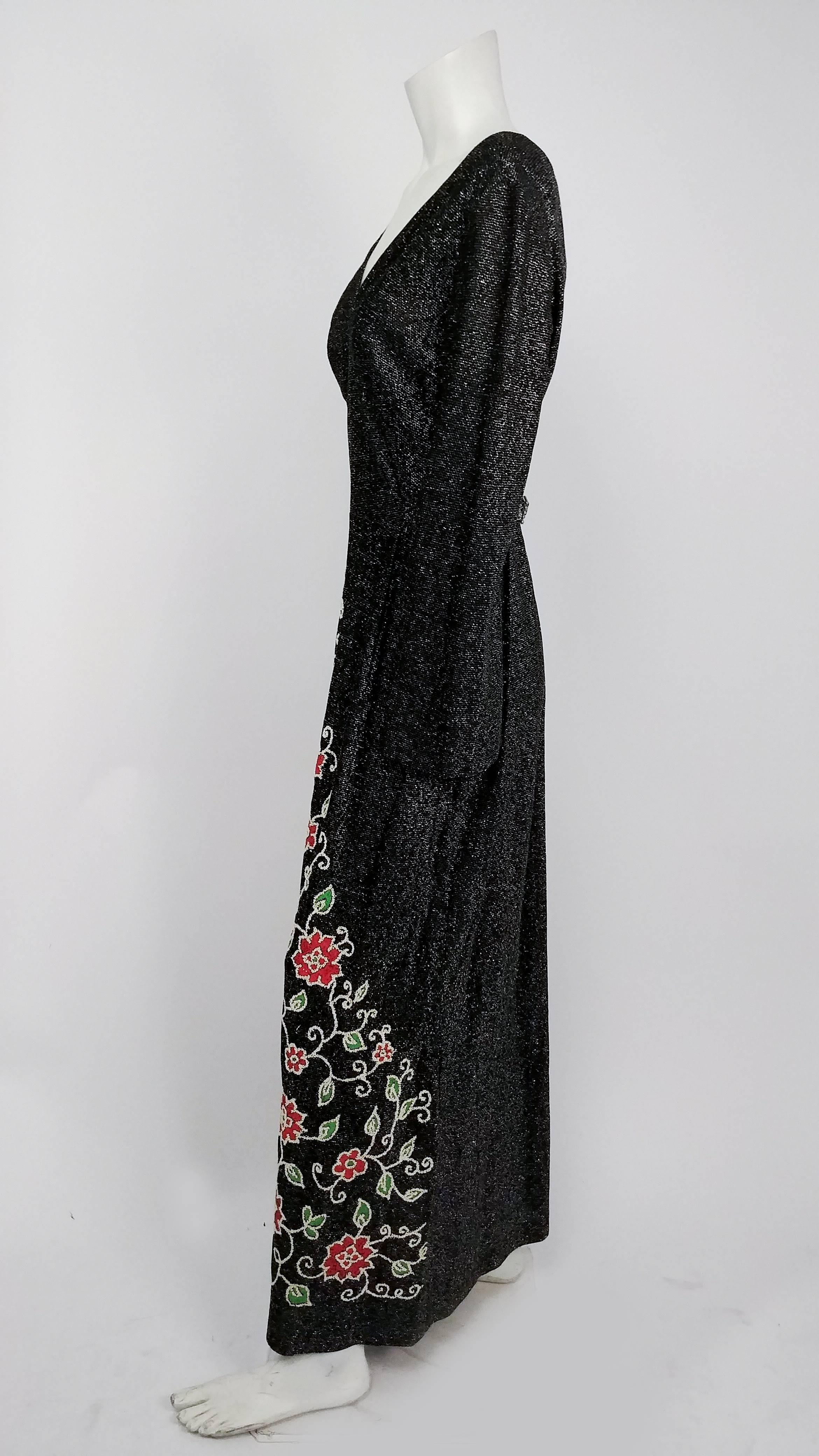 1970s Black Lamé Jersey Maxi Dress . V-neck collar, attached belt with rhinestone buckle at back, and beaded flowers at skirt of hem.