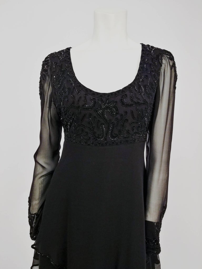 1960s Lillie Rubin Black Silk Chiffon Beaded Cocktail Dress. Beaded chiffon top, sheer sleeves with beading on shoulders. Empire waist. Ruffled kerchief hem with beading. About a US size 8