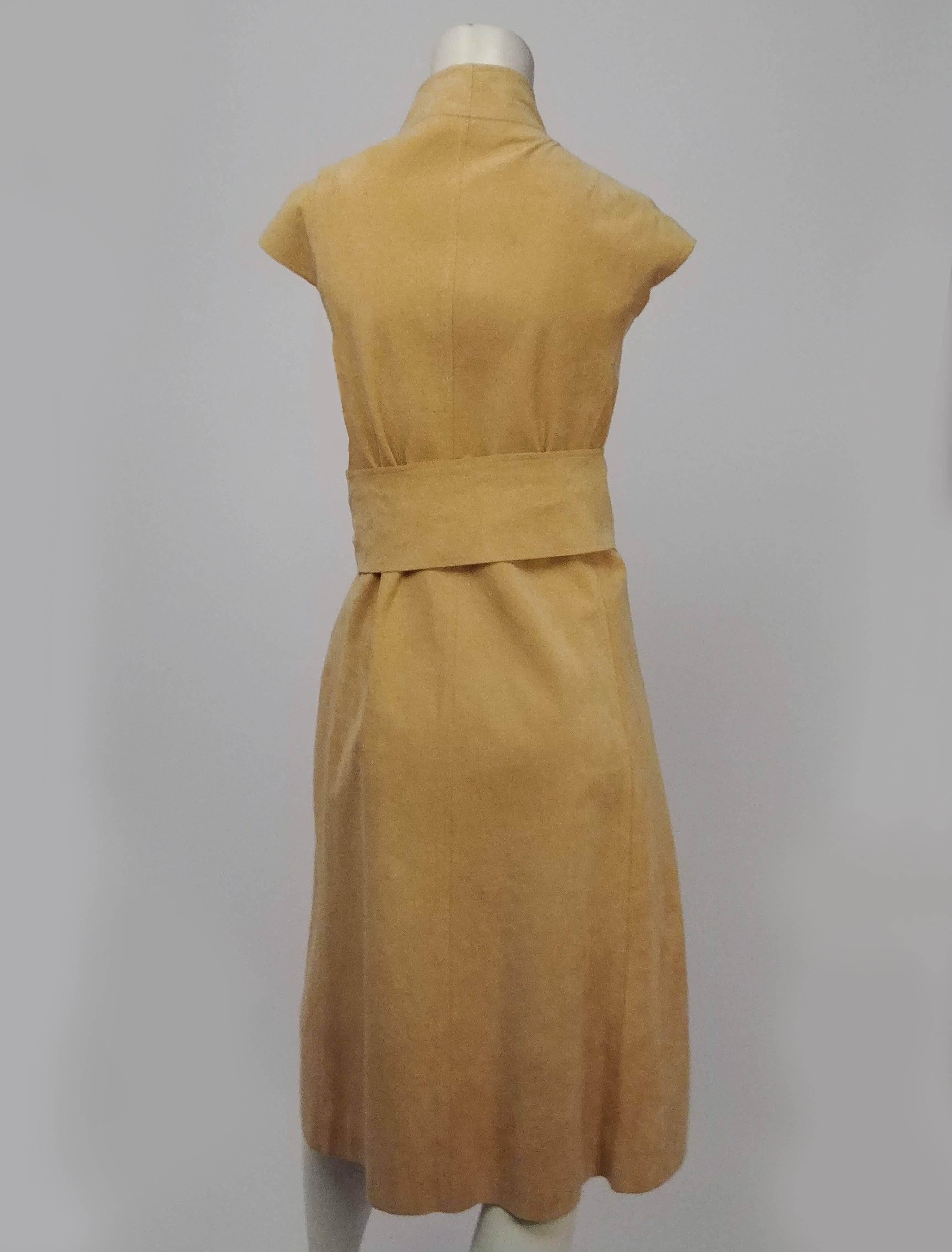 1980s Halston Vegan Suede Wrap Dress. Tan vegan suede wrap dress features structured collar and cap sleeves. Closes at front with snaps, and ties closed with removable belt. Full flared skirt. 