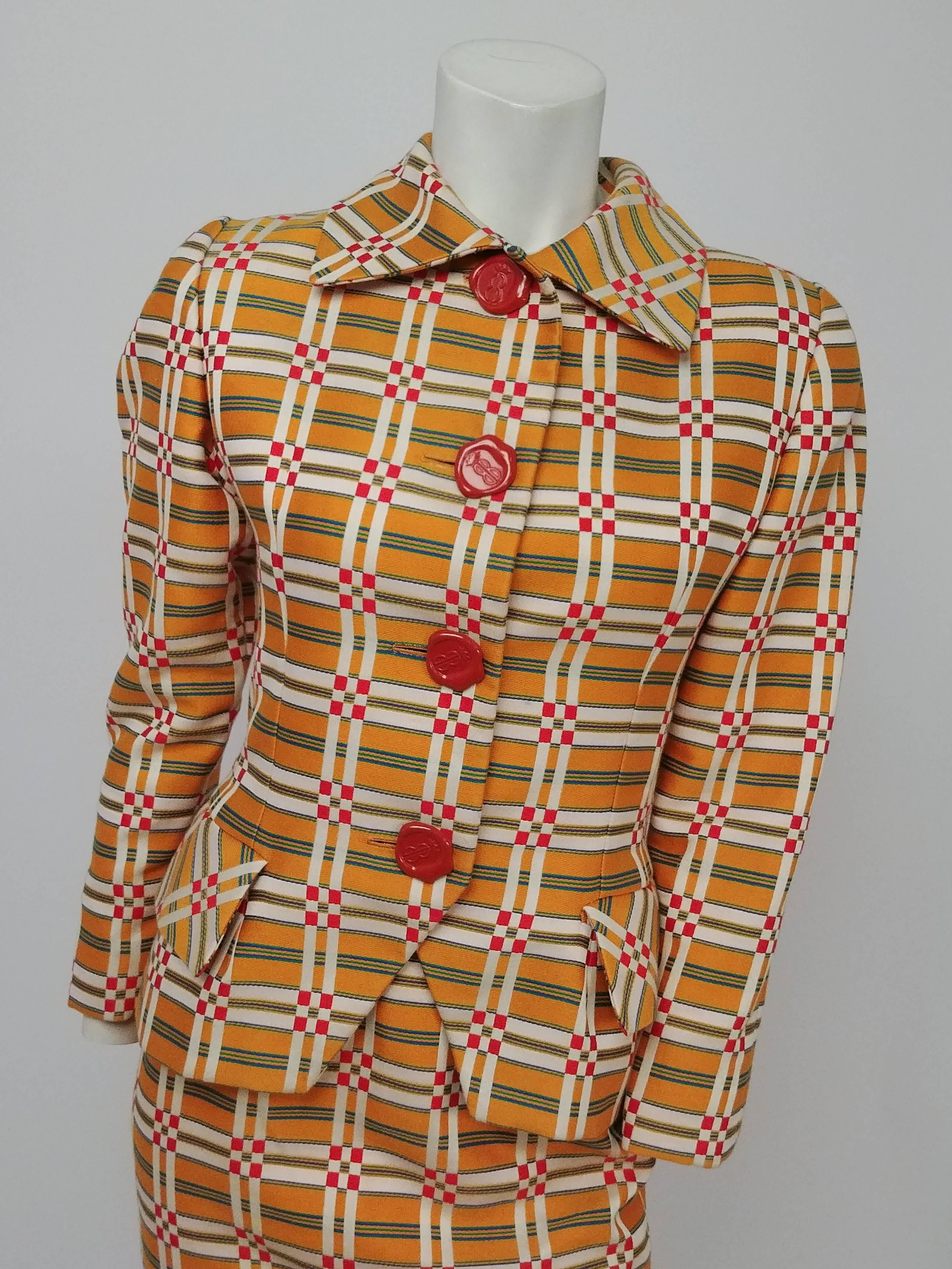 1980s Bill Blass Orange Plaid Skirt Suit w/ Wax Seal Buttons. Bright and colorful Bill Blass suit consists of jacket with rounded collar and skirt. Jacket has padded shoulders and big decorative red buttons that look like wax seals. 