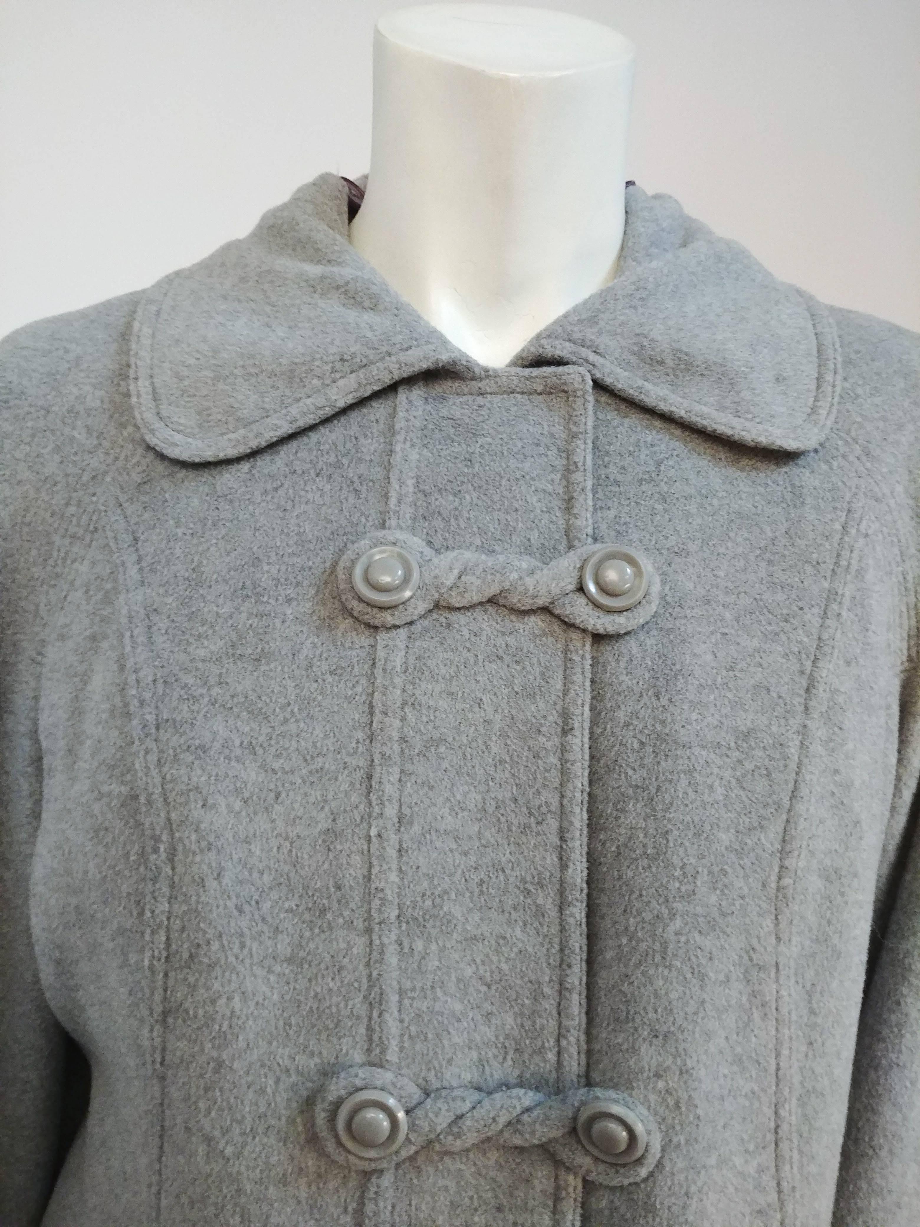 1970s Grey Wool Hooded Coat. Detachable hood buttons on at neck. Frog claps down front. Faux fur lining can be unzipped and removed for lighter wear. Beautiful quilting detail on coat facing. 