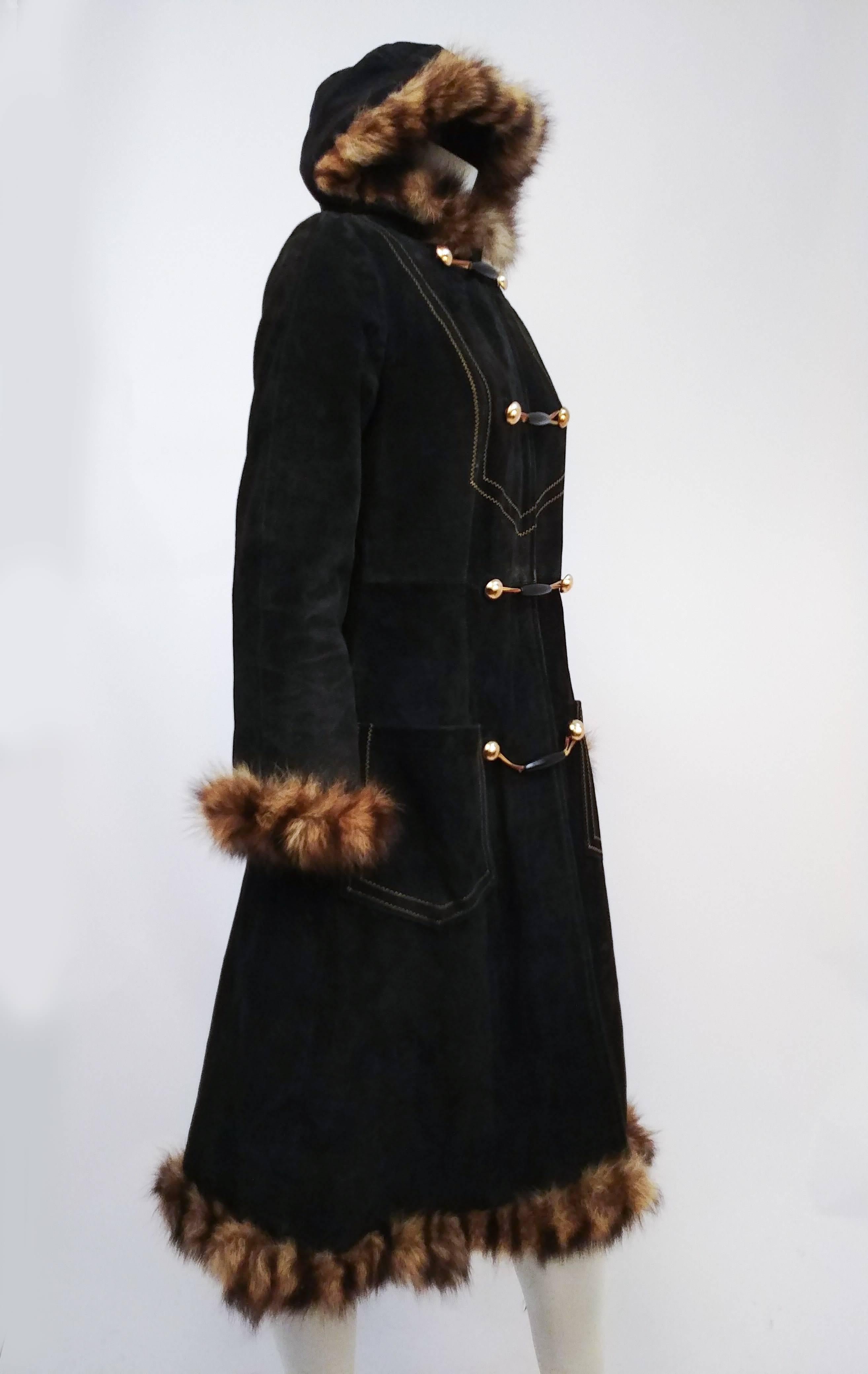 1970s Black Suede Leather Coat w/ Raccoon Trim. Decorative topstitching on coat front. Fur trim on hood, sleeves, and hem. 