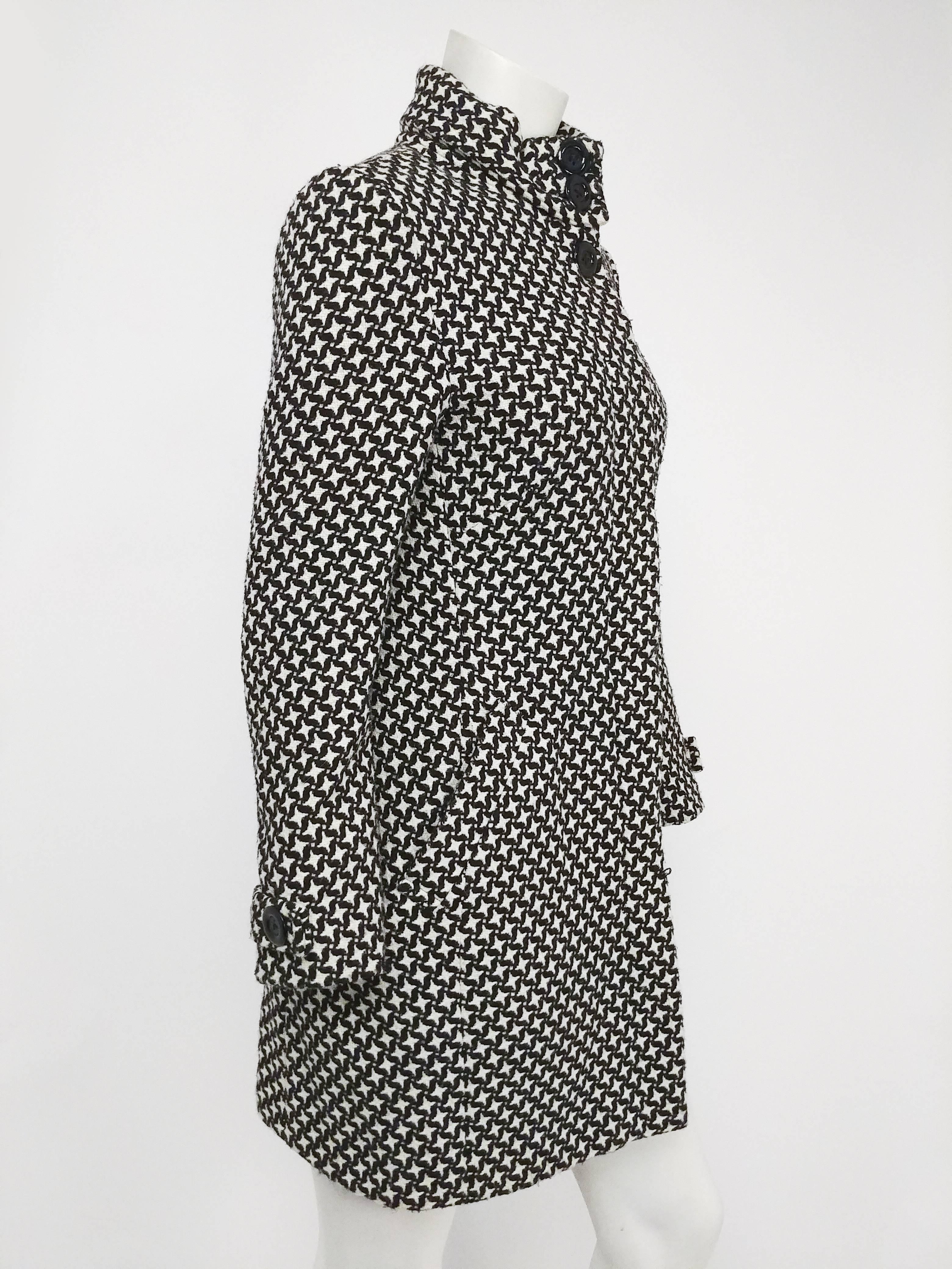 1960s Black & White Houndstooth Mod Coat. Straight waisted silhouette and mini-skirt length in a 1960s mod style. Hidden placket buttons up front, high collar. Two side pockets. Bright yellow lining adds touch of fun and color.