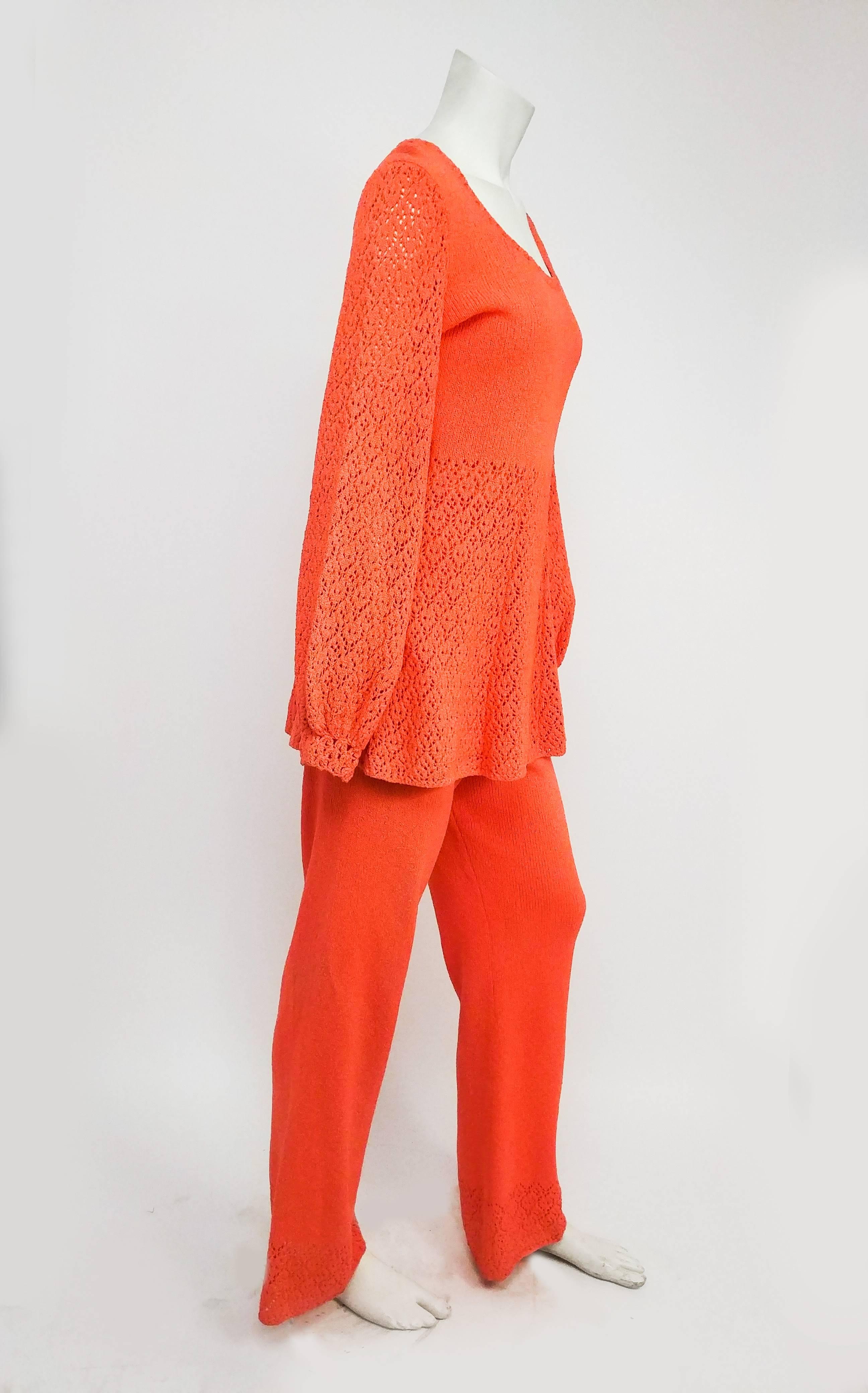 1970s Orange Crochet Two Piece Set. Tunic top nips in at natural waist and flares out with open crochet work. Long sleeves are elasticized at wrists to create balloon effect. Zips up back. Elasticized waistband on pants, flared legs. 