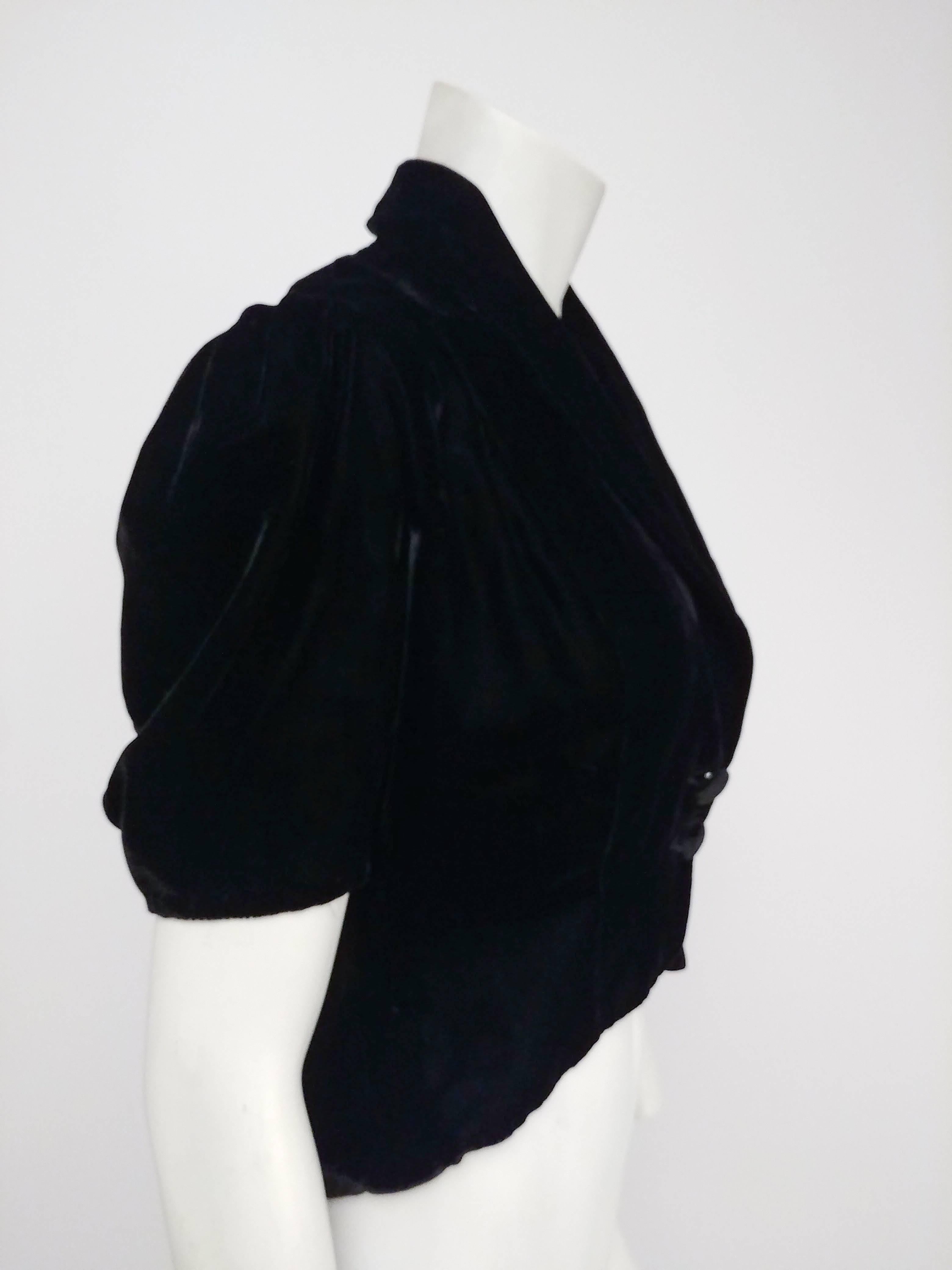 1940s Black Velvet Puff Sleeve Jacket. Adorable puff sleeves and a pointed back peplum are the starring features of this jacket. A plunging shawl collar ends closes with two buttons at front. 