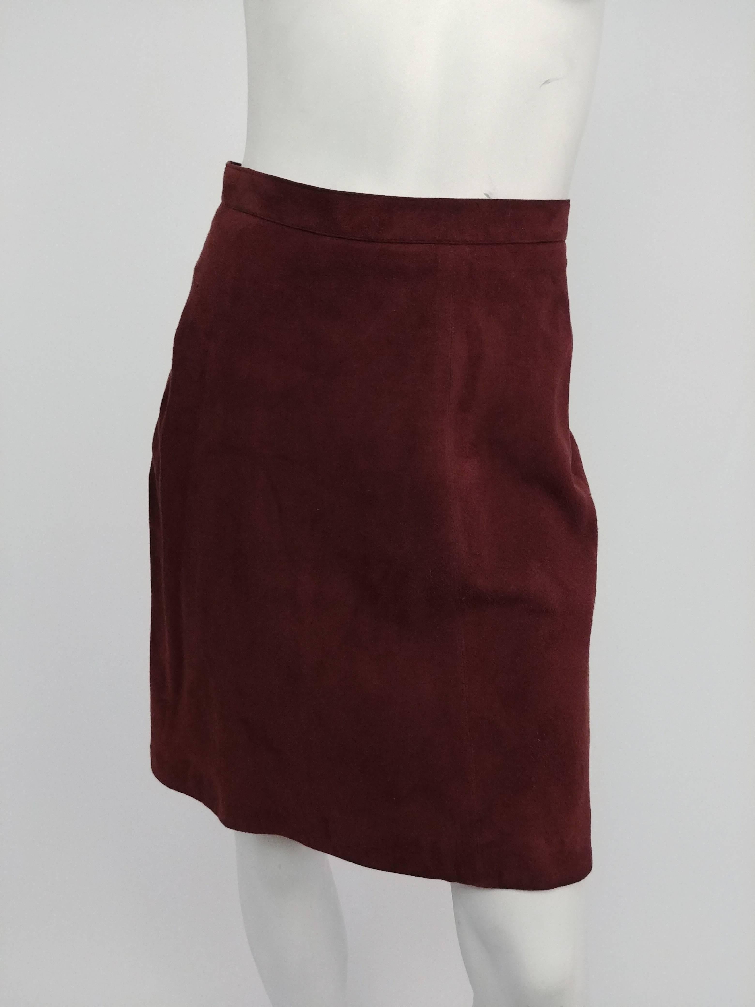 1990s Alaia Brown Vegan Suede Back Pleat Skirt. Brown suede skirt hits above the knee with A-line flare. All the details are at the back of the skirt, from flattering curved seam lines over to the bustle-like pleats. Zips up back and closes with a