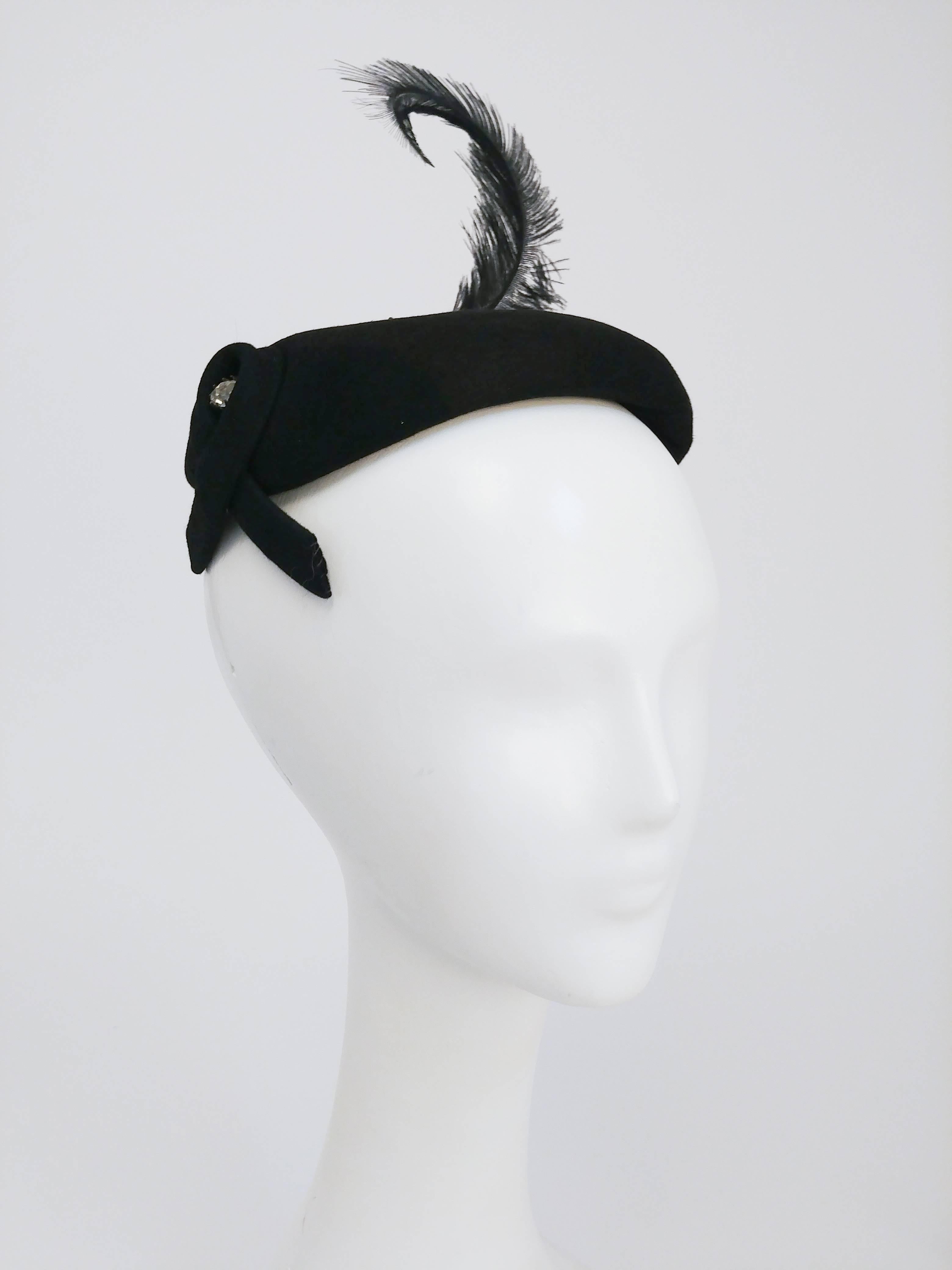 1950s Black Cashmere Felt Cocktail Hat. Black cashmere felt cocktail hat with feather hat and rhinestone accents. Elastic to secure hat to head. Open-Sized.