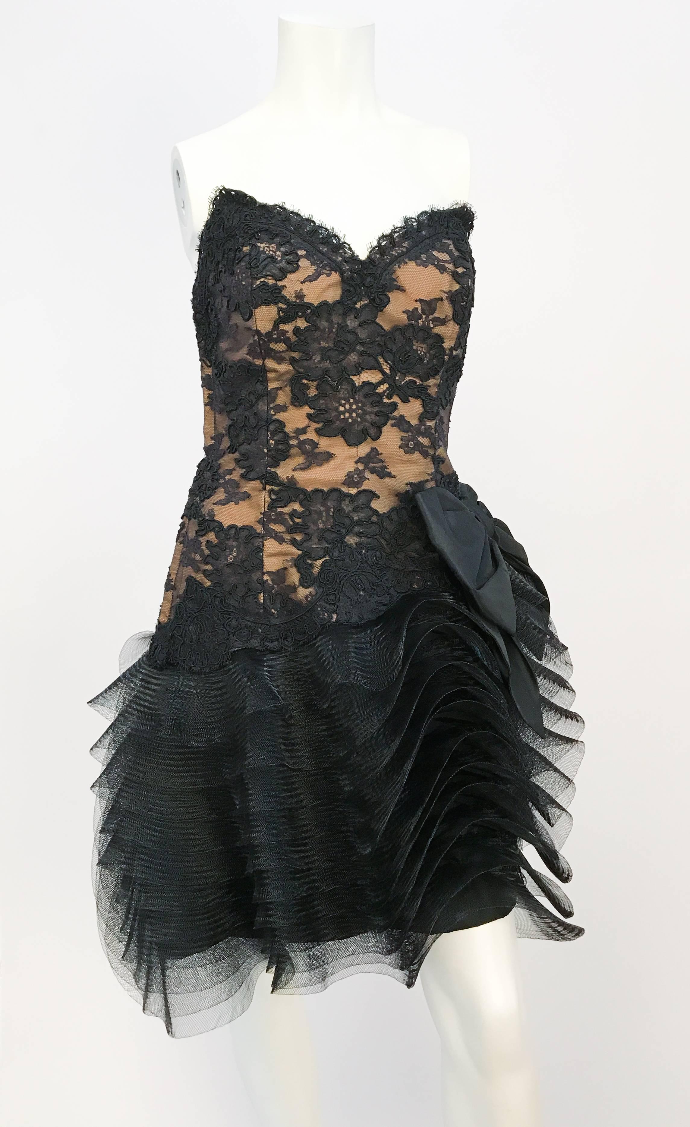 1980s Victor Costa Black Strapless Lace and Tulle Dress. Black strapless floral lace dress with layered sculpted tulle, drop-waist, and bow on the side. Side zip closure. 