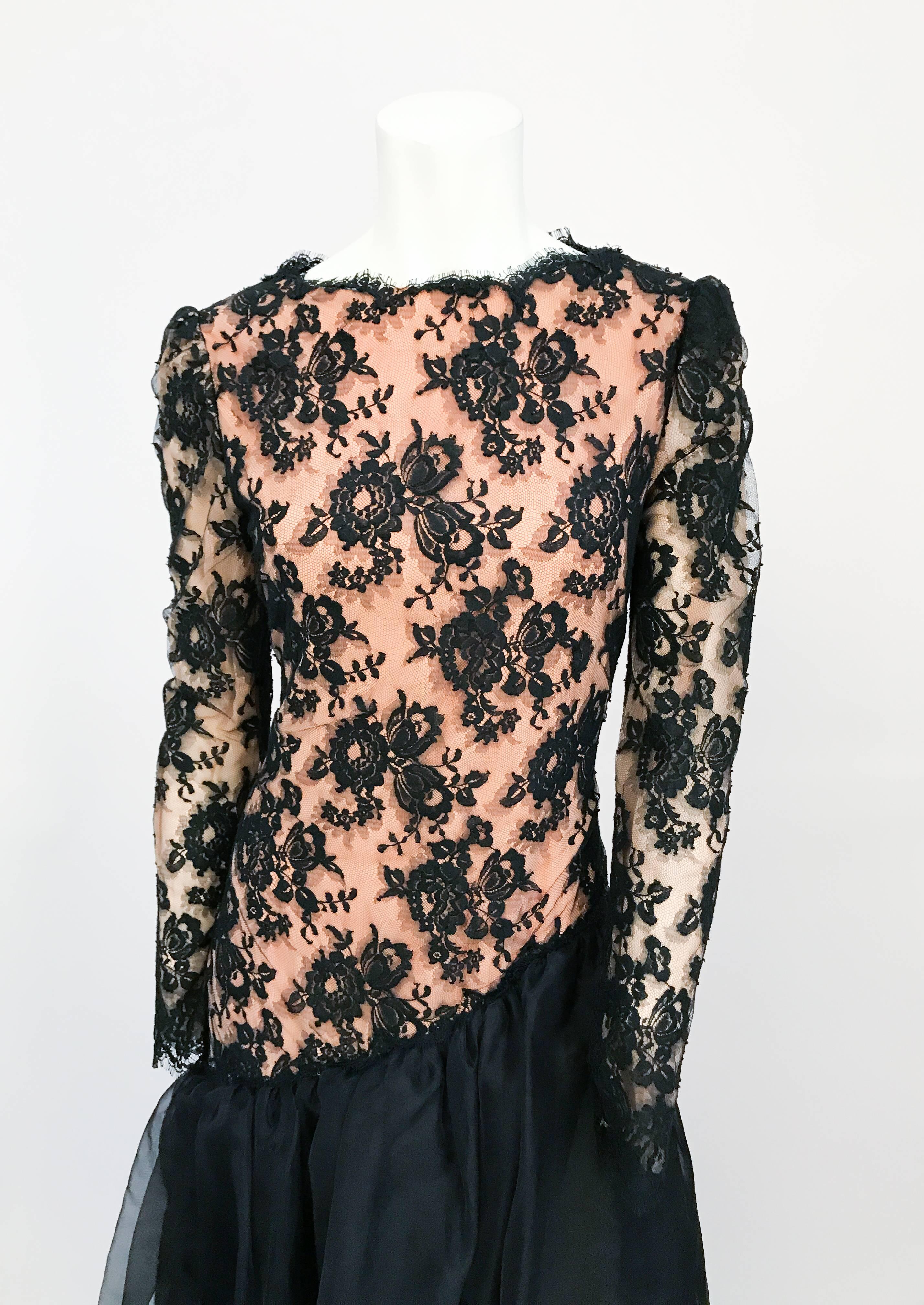 1980s Travilla Black Floral Lace Dress. Black Floral Lace dress with full sleeves, drop waist, and black sheer flare. Peach color lining that can be seen through the black floral lace.