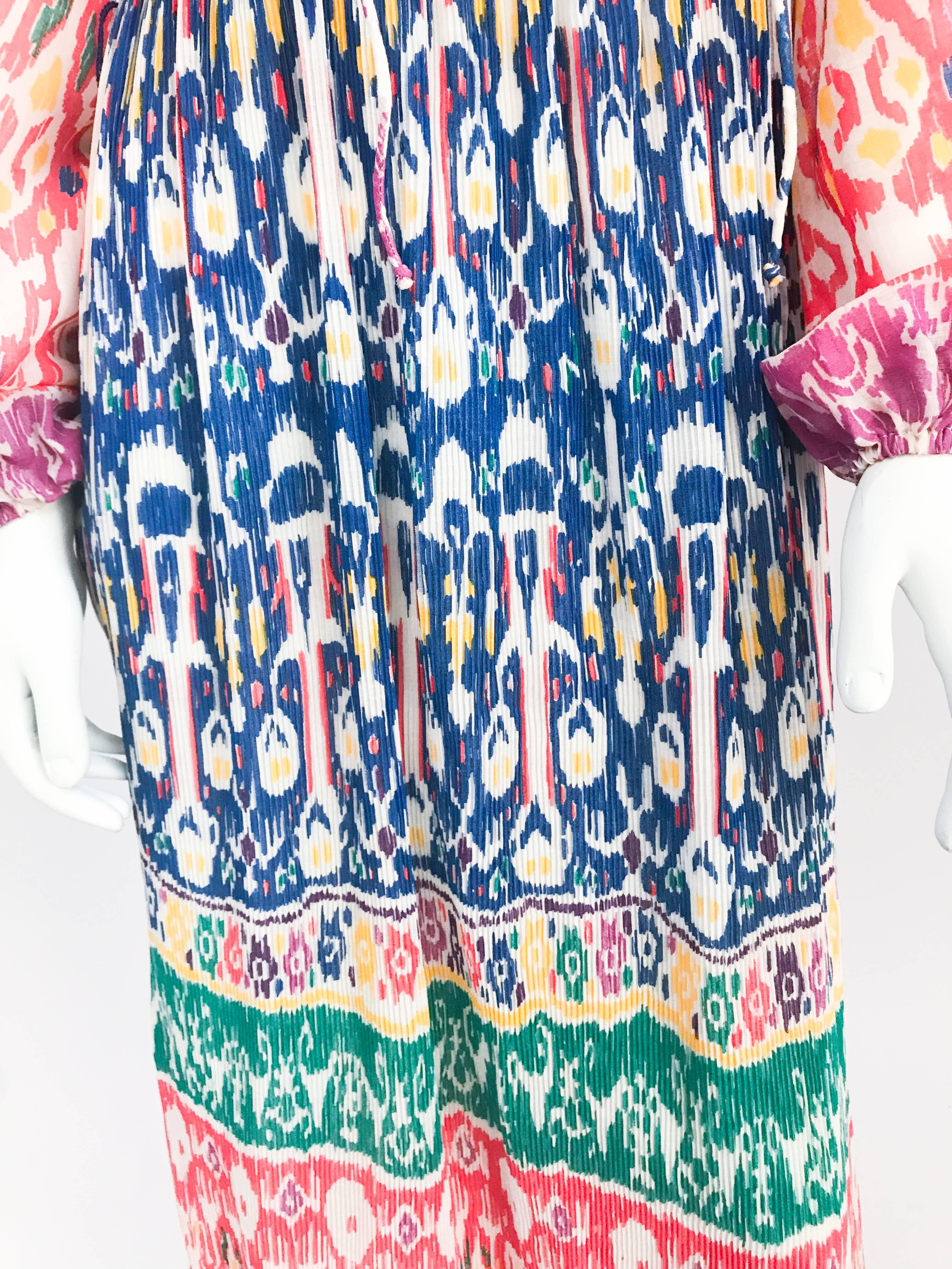 1970s I. Magnin Pleated Impressionist Printed Day Dress. Multi-colored day dress with micro-pleated skirt, bell sleeves, v-shaped neck line with tie closure, fully lined, and impressionist print.