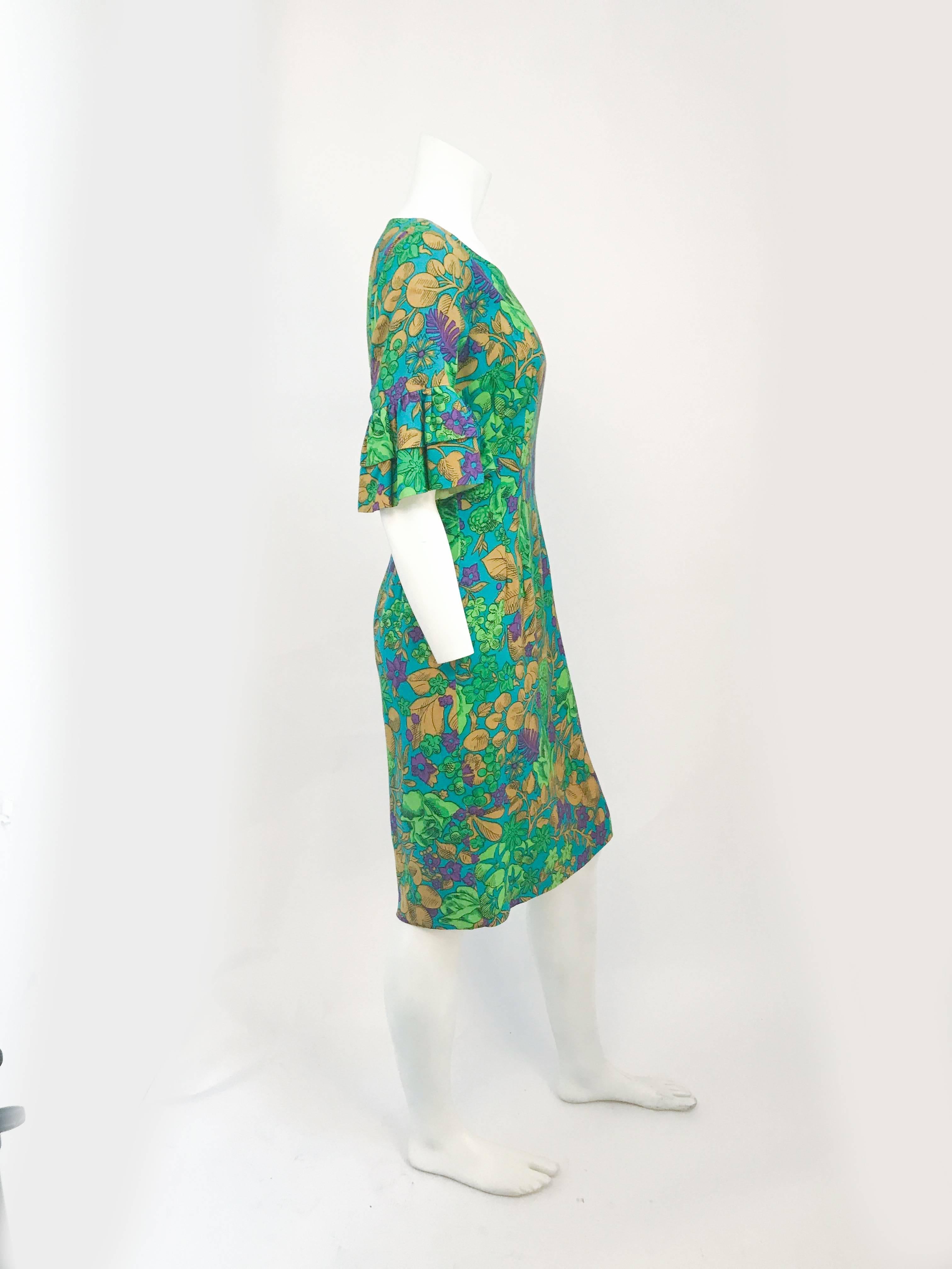 Vestido entallado, floral y con mangas de campana con volantes, verde de los años 60. Vestido verde con estampado floral en varios tonos, mangas de campana con volantes de 2 niveles. El vestido también es entallado, ya que tiene varias pinzas a lo