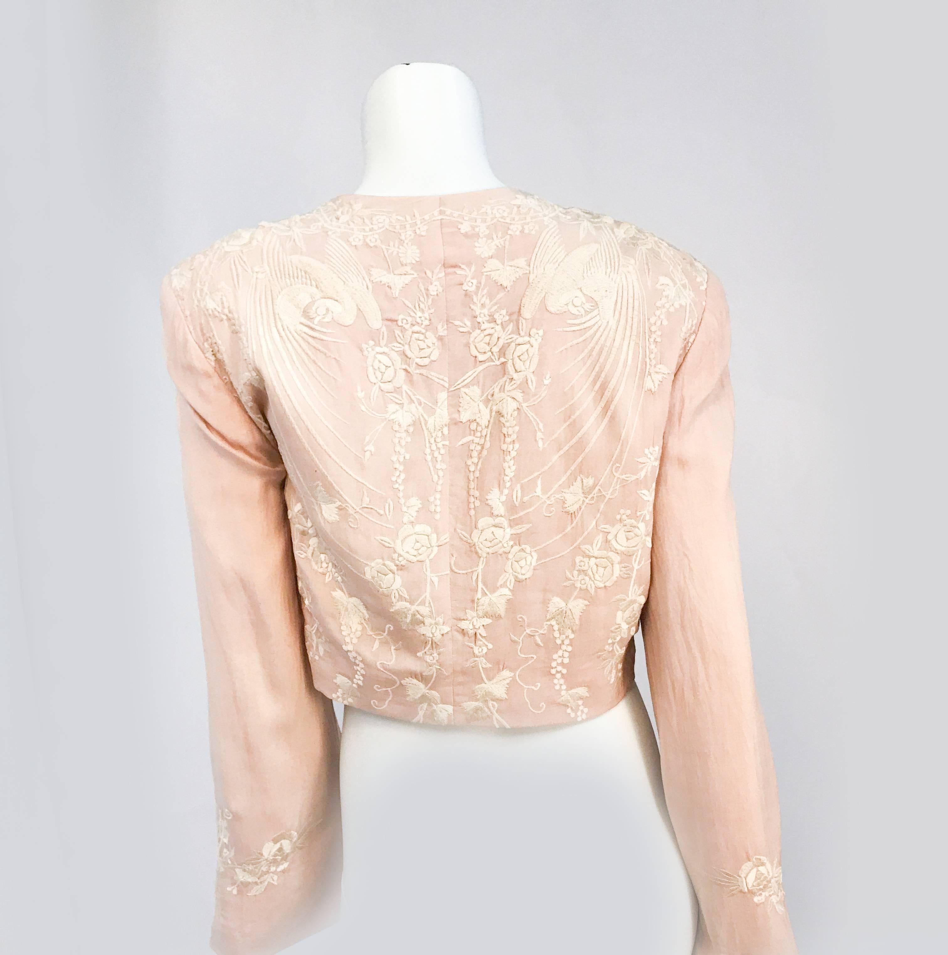 1980s Pale Rose Silk Embroidered Bolero. Pale rose silk bolero with machine embroidery along the face of the garment and the sleeves. Sleeves have a slight bell shape to them and the shoulders are padded.