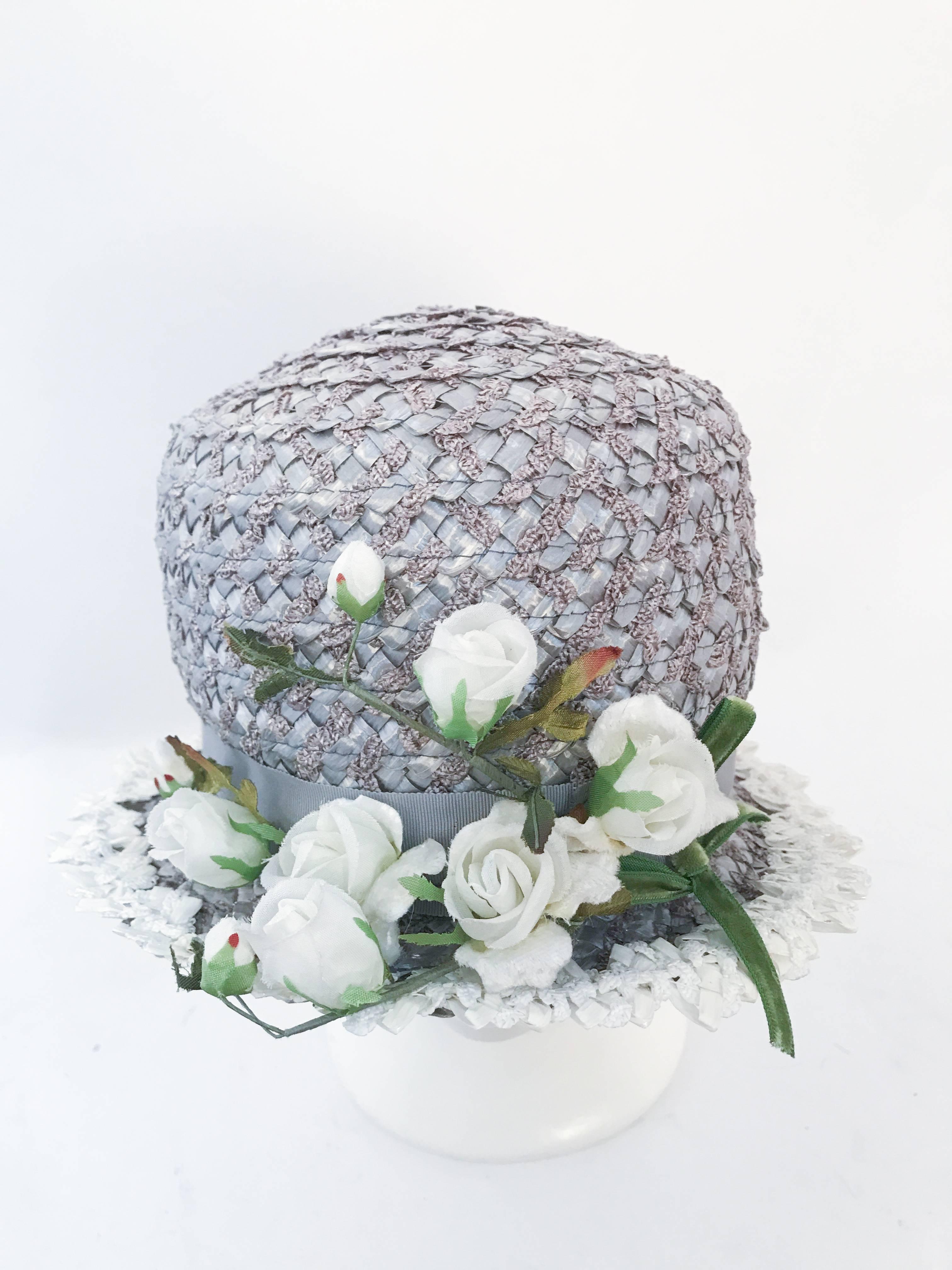 1960s Grey Raffia Cloche with Roses. Grey raffia hat with white silk and silk velvet roses, and white trim along the brim.