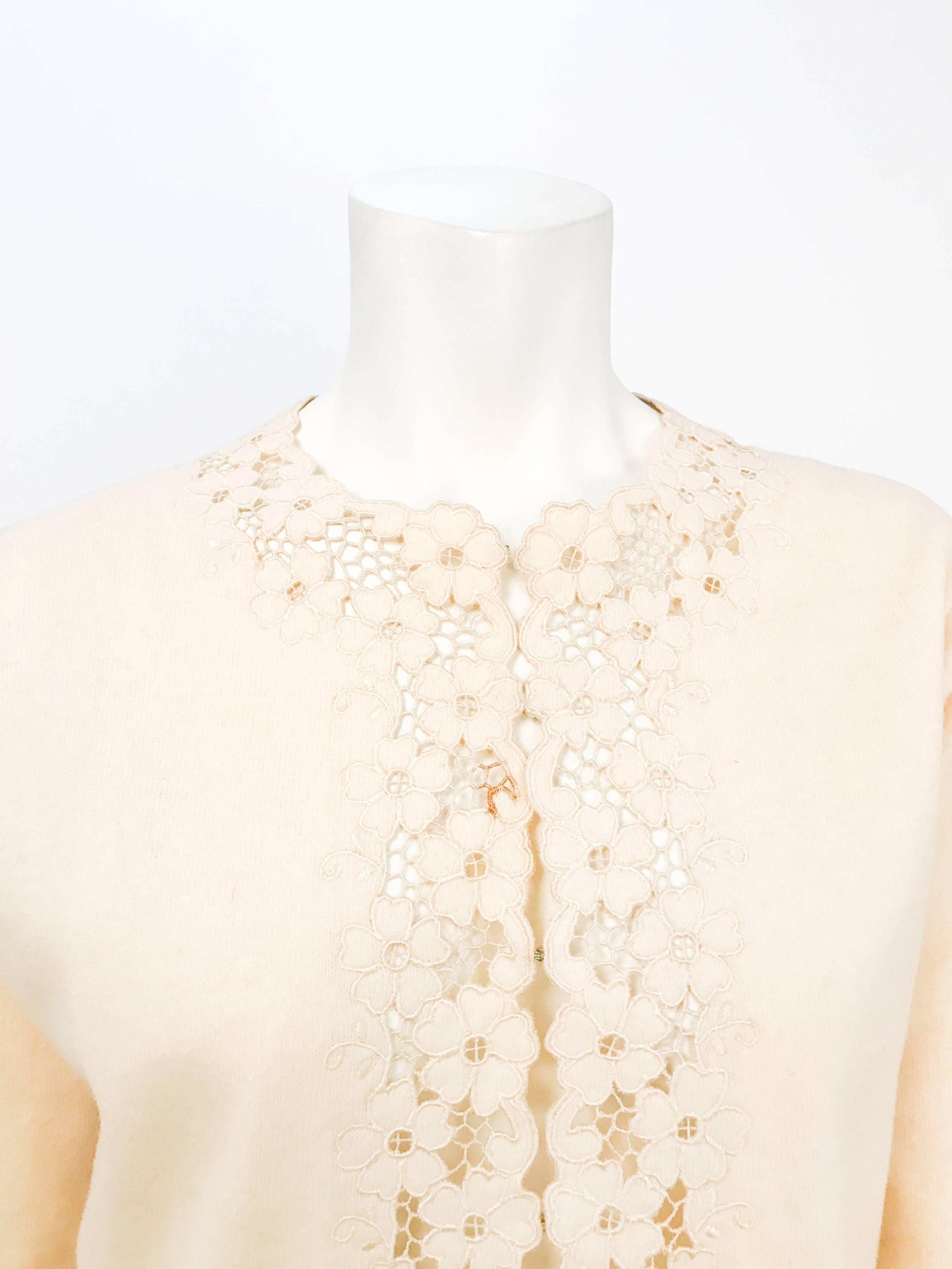 1950s Cream Wool Cardigan with Embroidery and Cut-work. Cream colored wool cardigan with embroidery and cut-work details along the neckline, opening and cuffs. Hook/eye closure along the front.