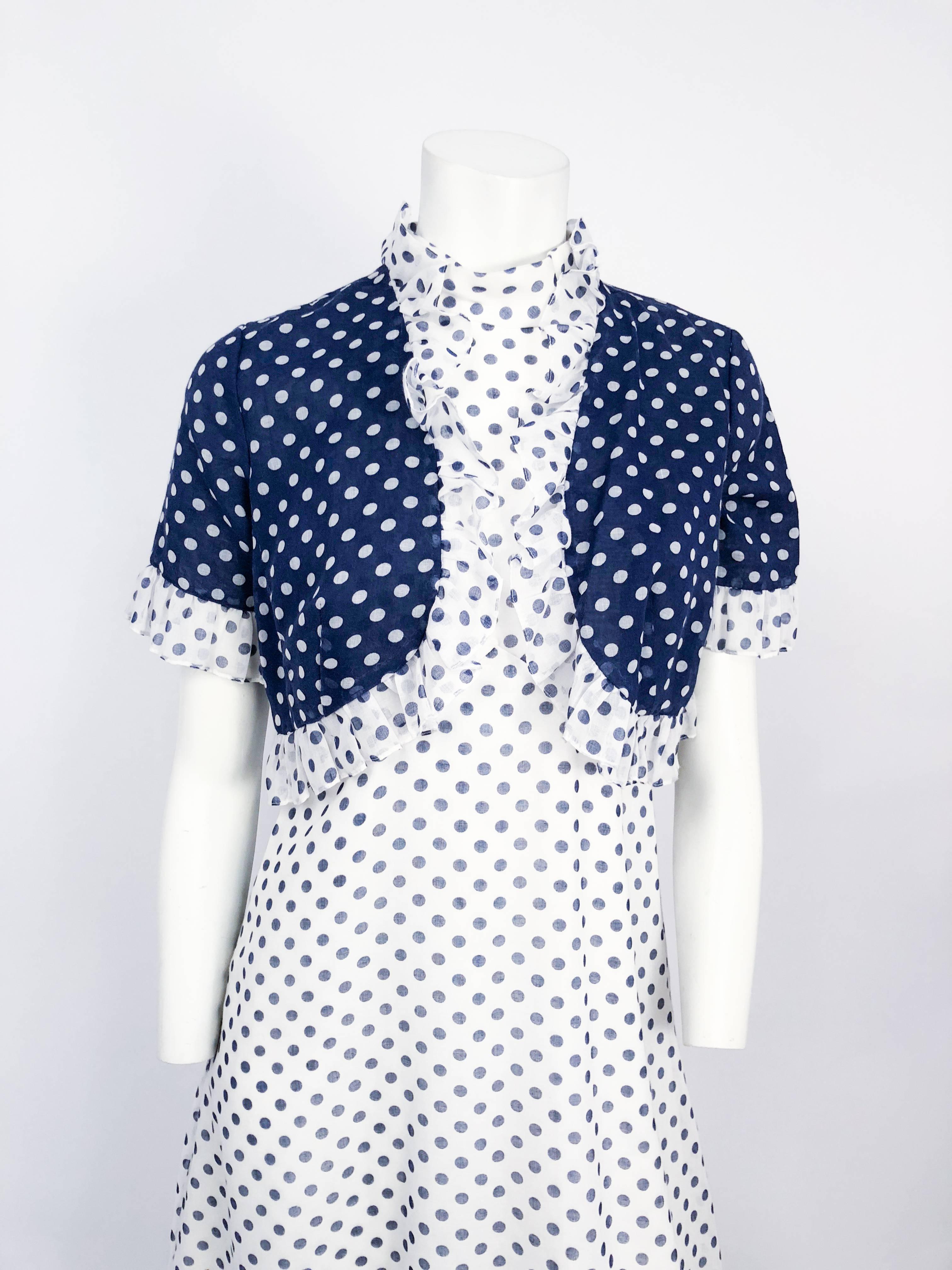 Abito anni '60 Lord & Taylor blu e bianco con bolero. Vestito blu e bianco a pois con top a balestra. Bolero abbinato con motivo inverso e bordi arruffati. Chiusura con cerniera in metallo lungo la schiena dell'abito. 
