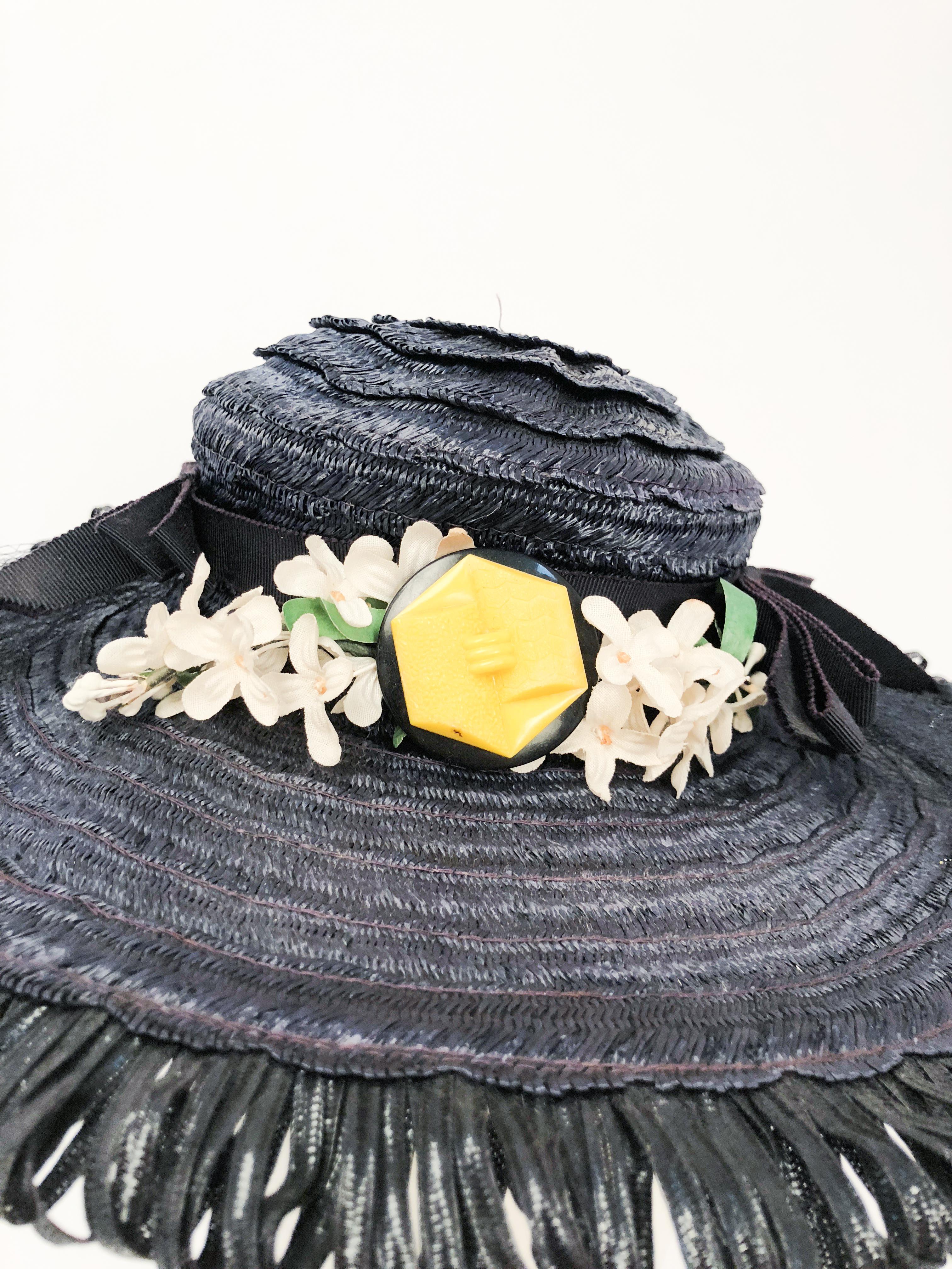 1940s Navy Woven Raffia Cartwheel Hat. Navy woven raffia cartwheel hat decorated with petersham bows, match hat band, silk flowers, draped veil and backbite buttons. Petersham hat band with elastic used to secure hat to head.