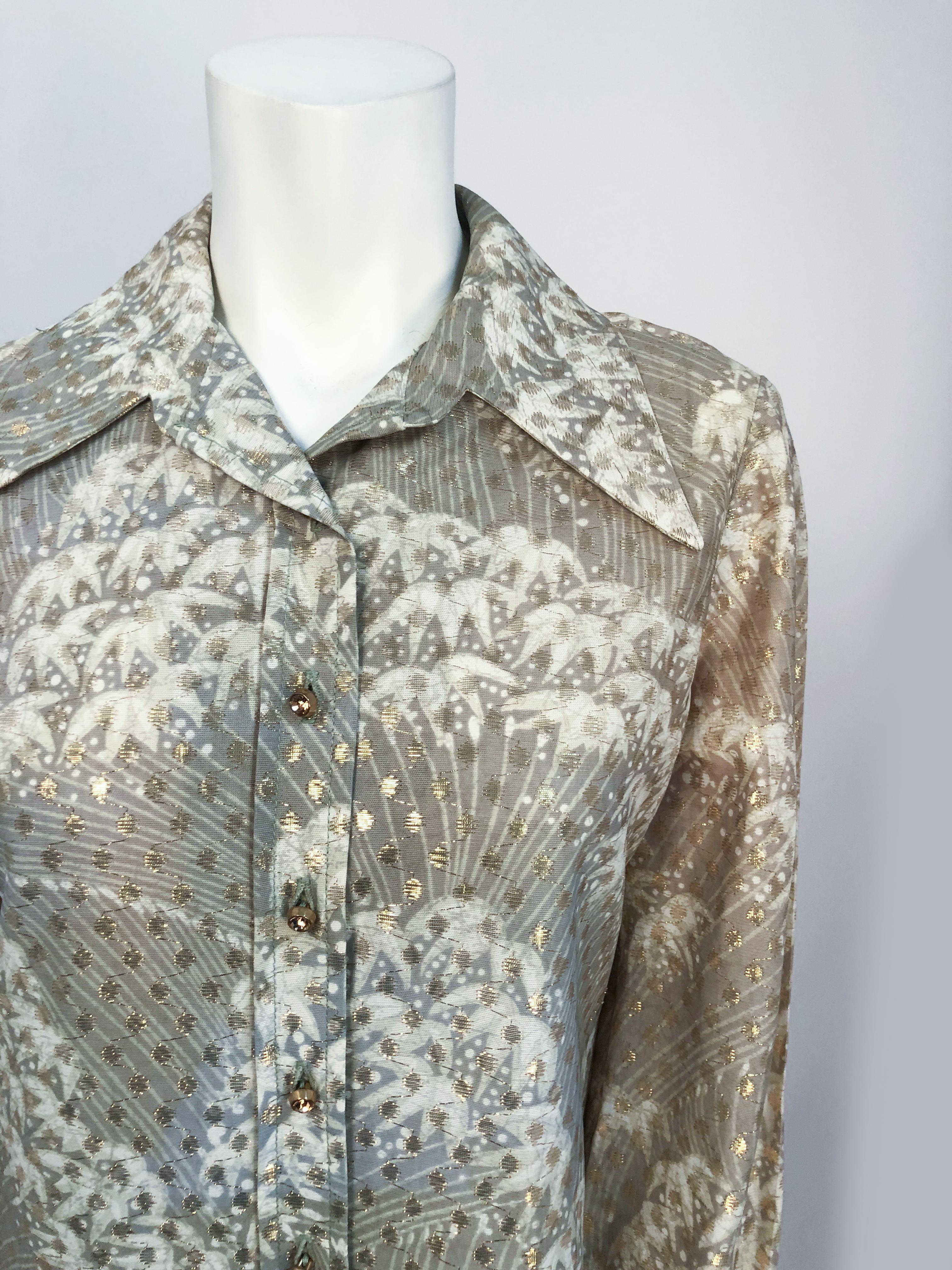 1970s I. Magnin Printed Shirt. Sage green and cream printed shirt with butterfly collar, cuffed selves, side vents, and amber rhinestone buttons. The fabric has a gold-toned lurex polka-dot pattern.
