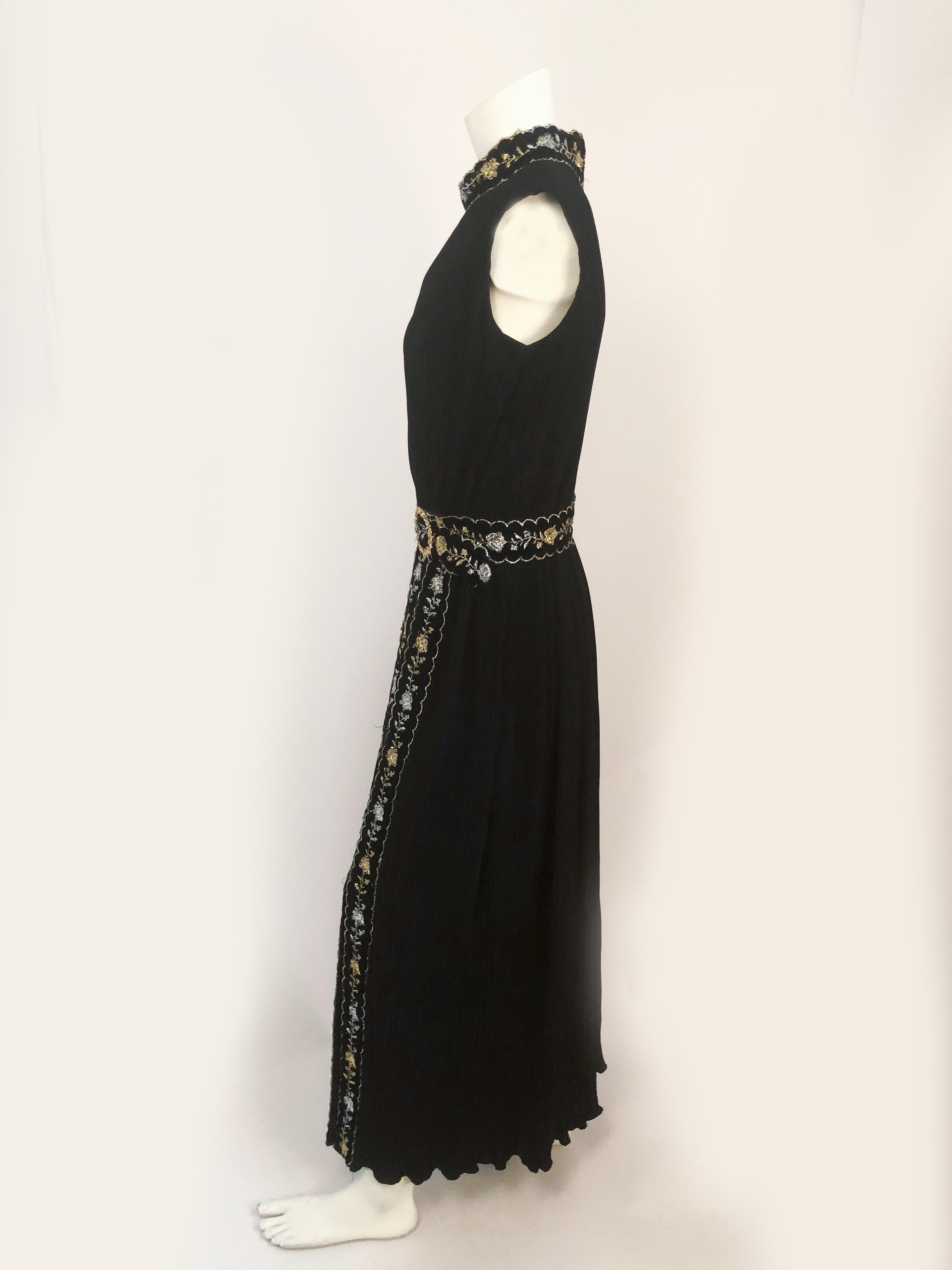1960s Black Pleated Sleeveless Dress with Velvet and Metallic Details. Velvet trim with gold/silver metallic toned laurex details and a floral brass belt buckle.